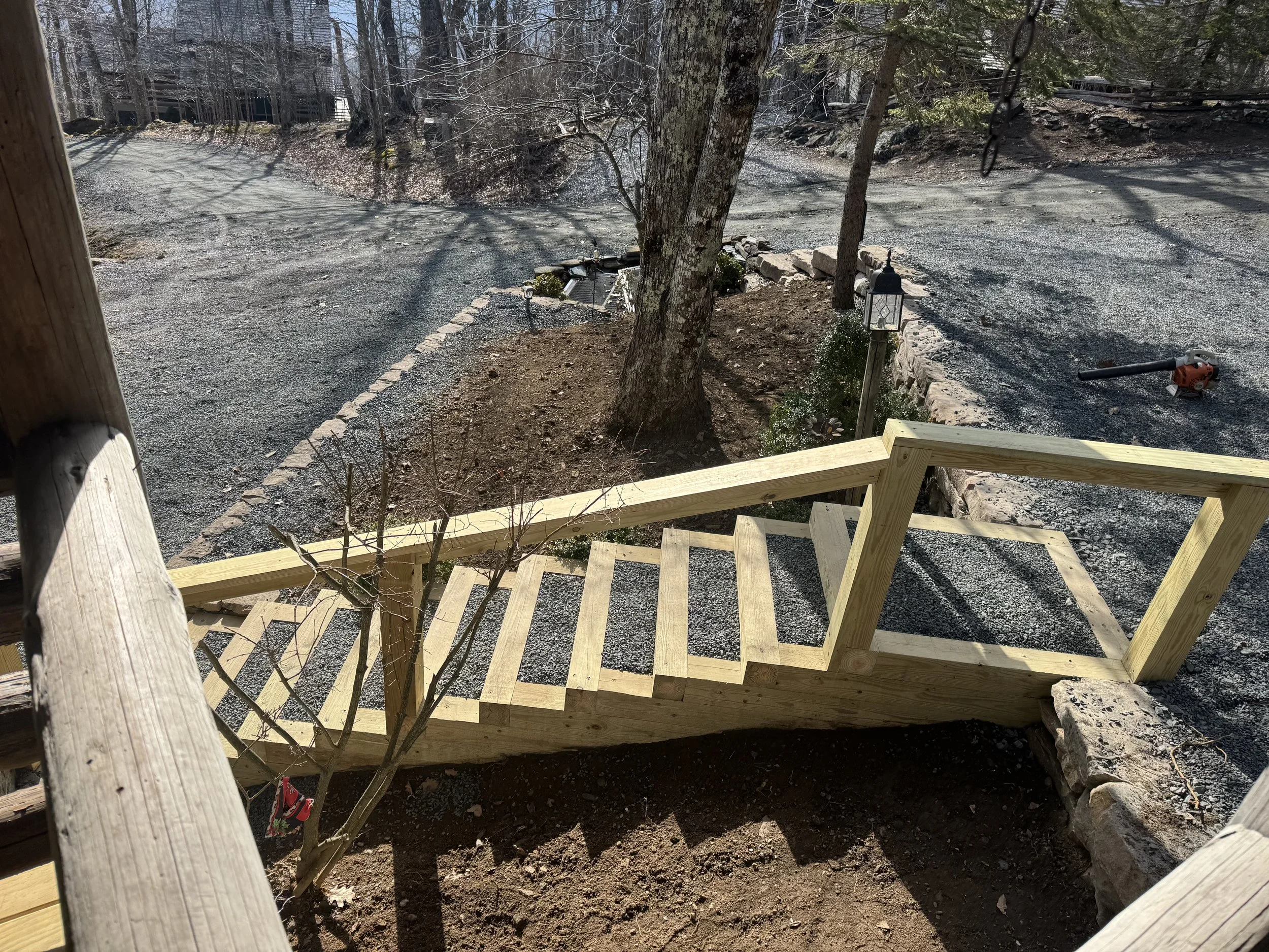 Wooden staircase leading from a house porch to the yard,by Antonio’s Construction providing exterior construction in Ashe County and Watauga County, NC