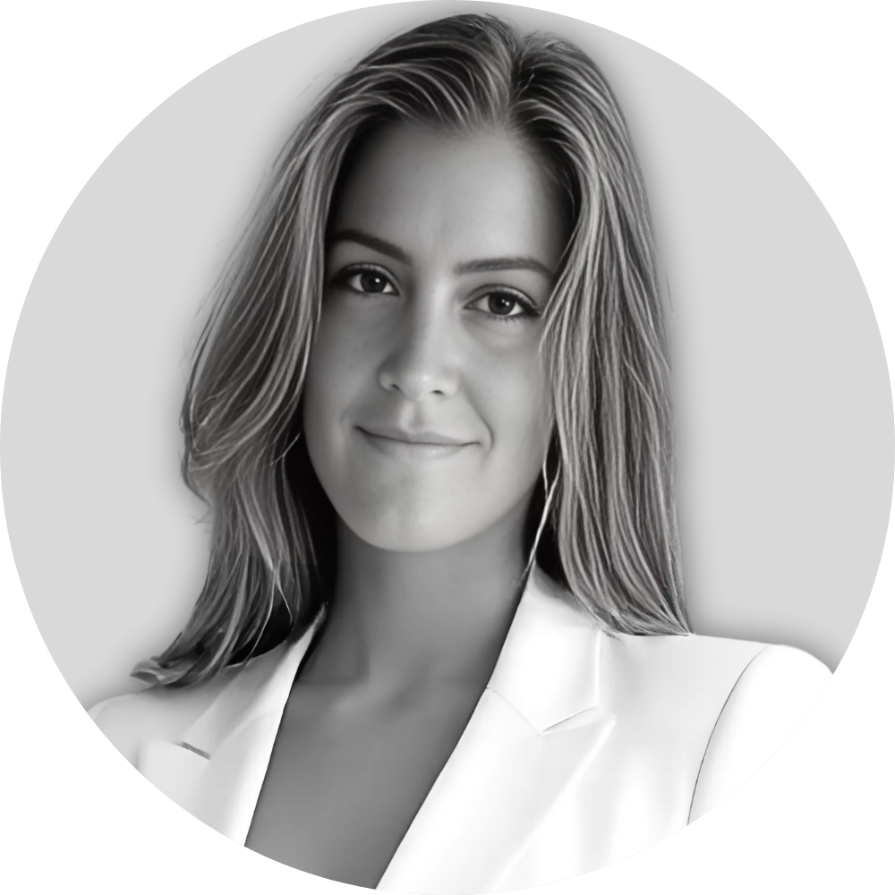 Black and white portrait of a young woman with shoulder-length hair, wearing a blazer and smiling slightly.