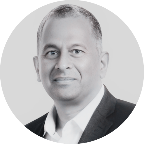 Black and white portrait of a man in a suit with a white shirt, smiling.