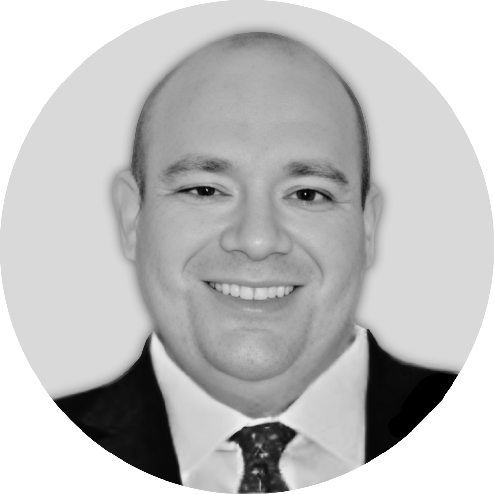 Black and white portrait of a smiling man wearing a suit and tie.