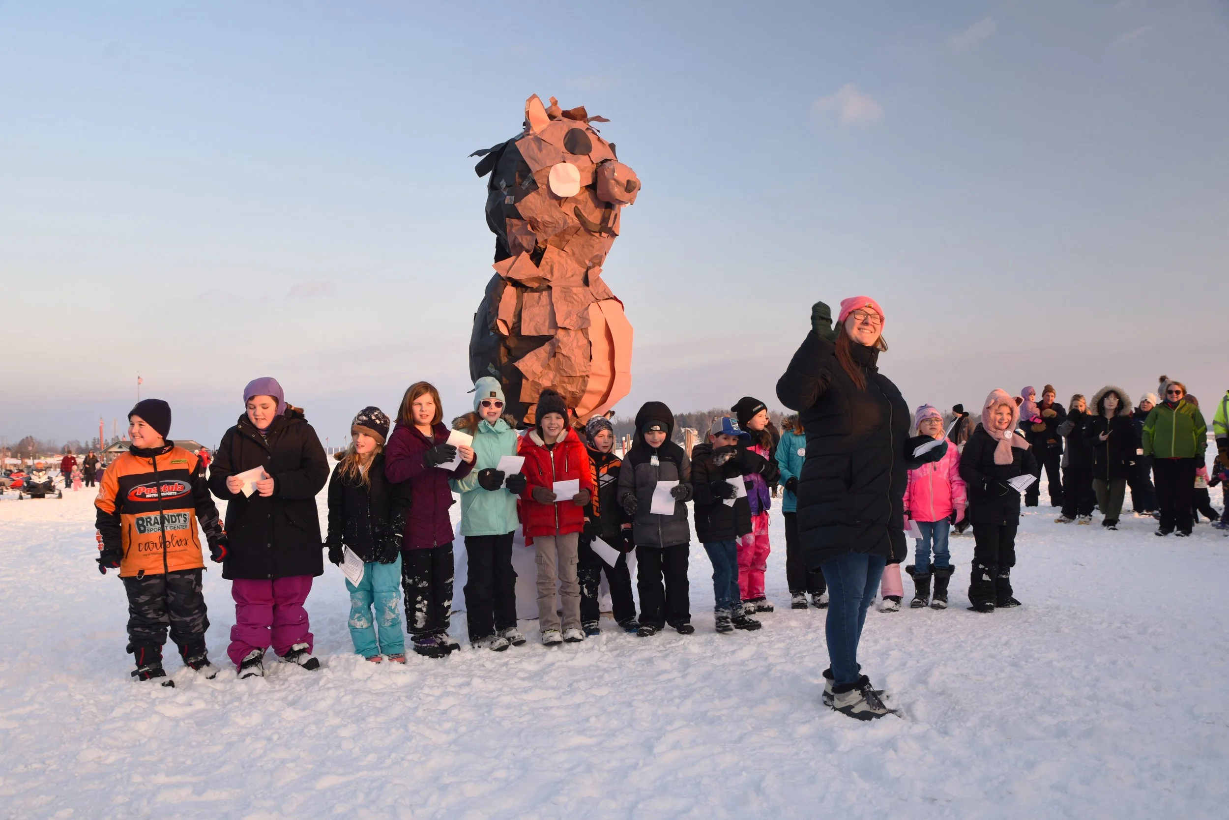 Children Outdoors at a winter festival with a paper made statue