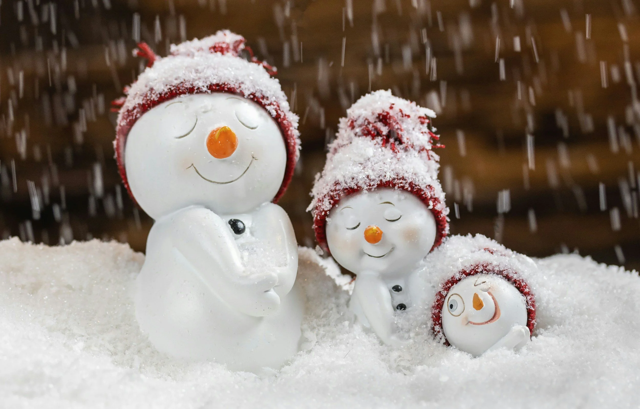 Ceramic snowman family on display with a snowy background