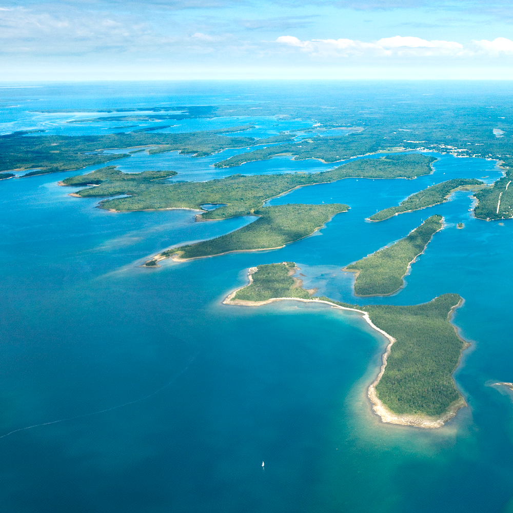 Aerial view of a large body of water with numerous green islands and peninsulas.