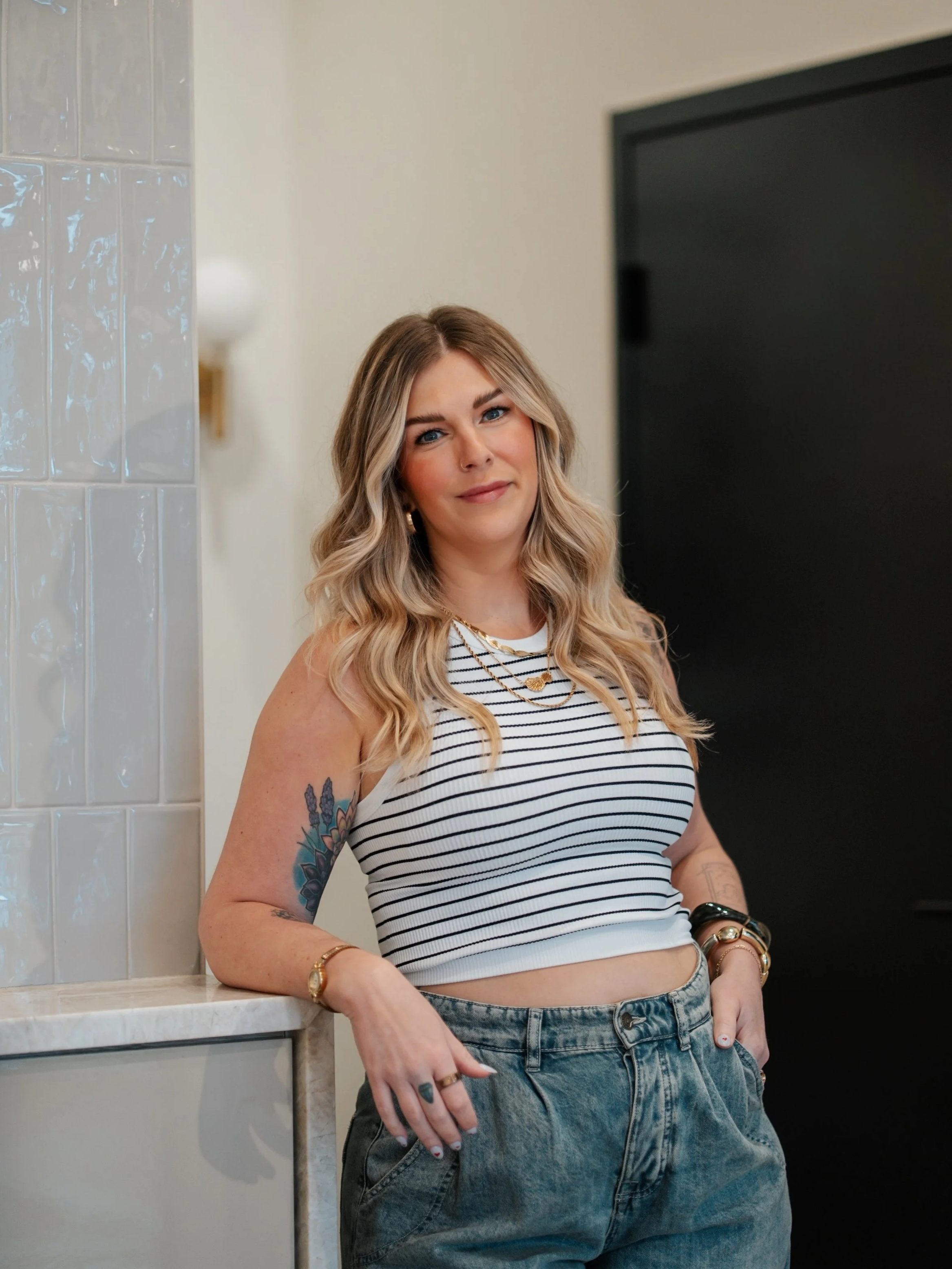 Blonde balayage hairstylist with tattoos