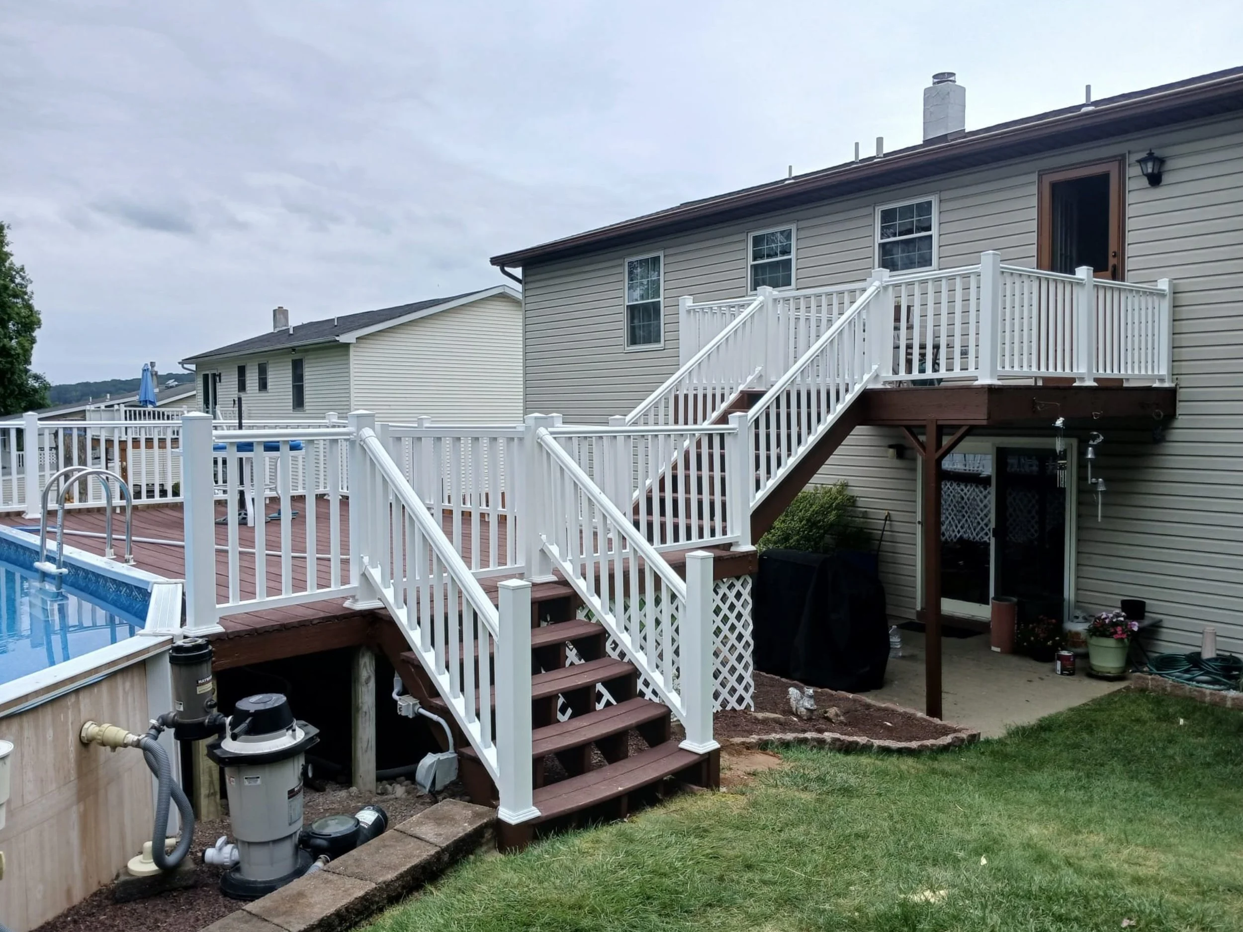 Custom poolside deck remodel with white railing and staircase completed by HM Remodeling serving South Bend, Elkhart, Mishawaka, and the Michiana area