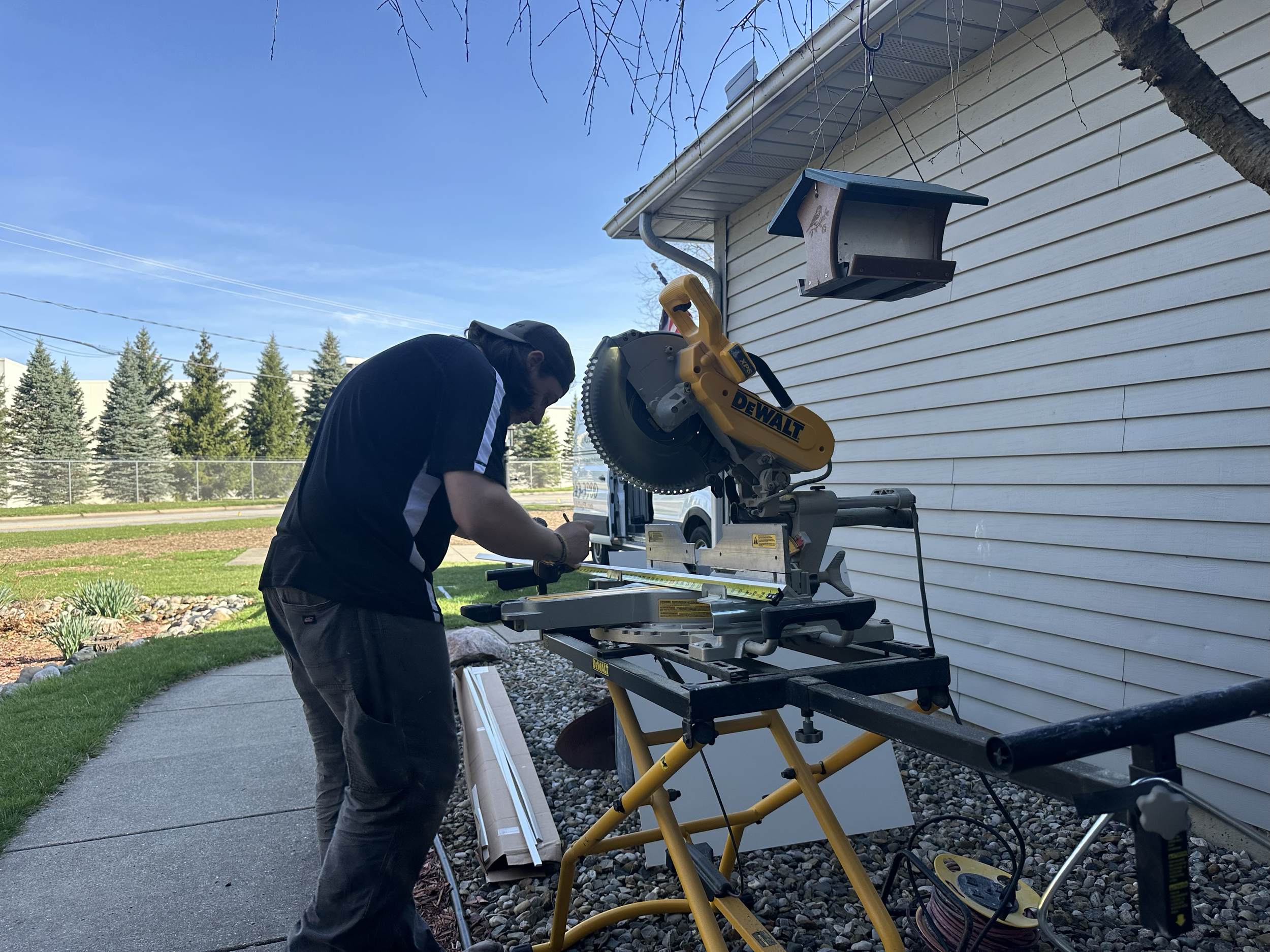 HM Remodeling contractor using a DeWalt miter saw to cut trim during a home remodeling project in South Bend, Indiana