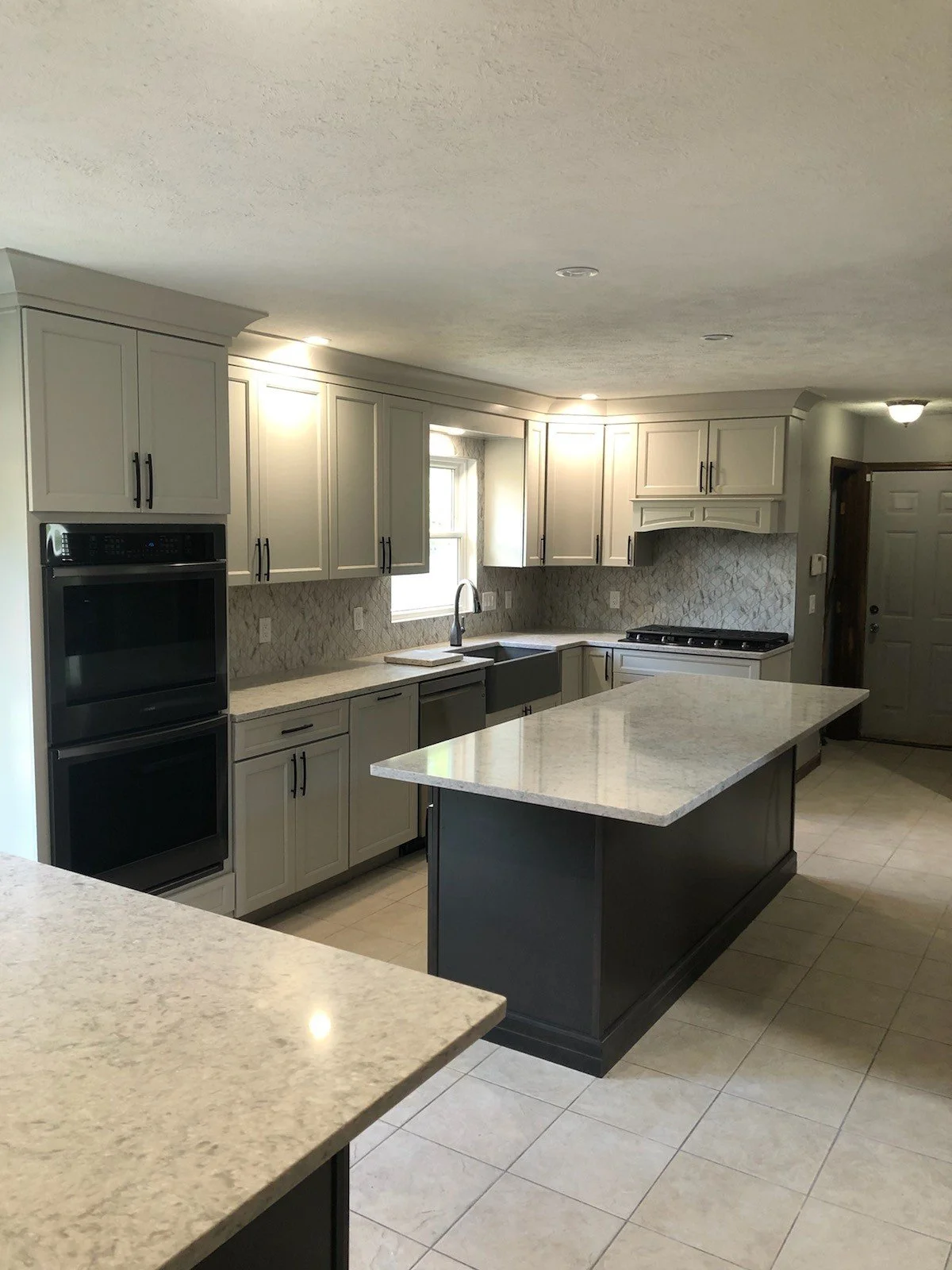 Custom kitchen remodel completed by HM Remodeling in Granger Indiana featuring white cabinets, quartz countertops, and a large island.