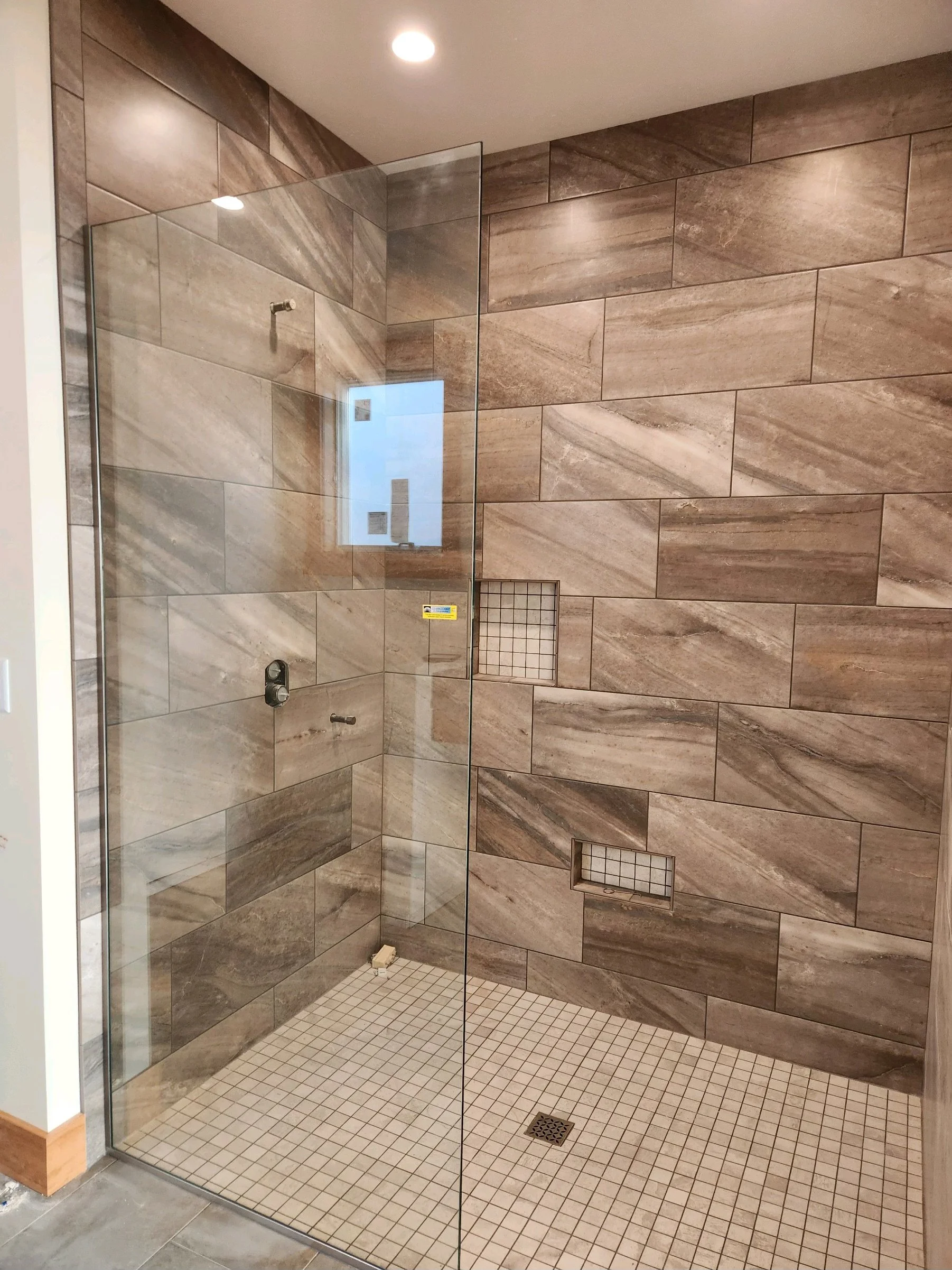 HM Remodeling custom tile shower with frameless glass enclosure in South Bend Indiana