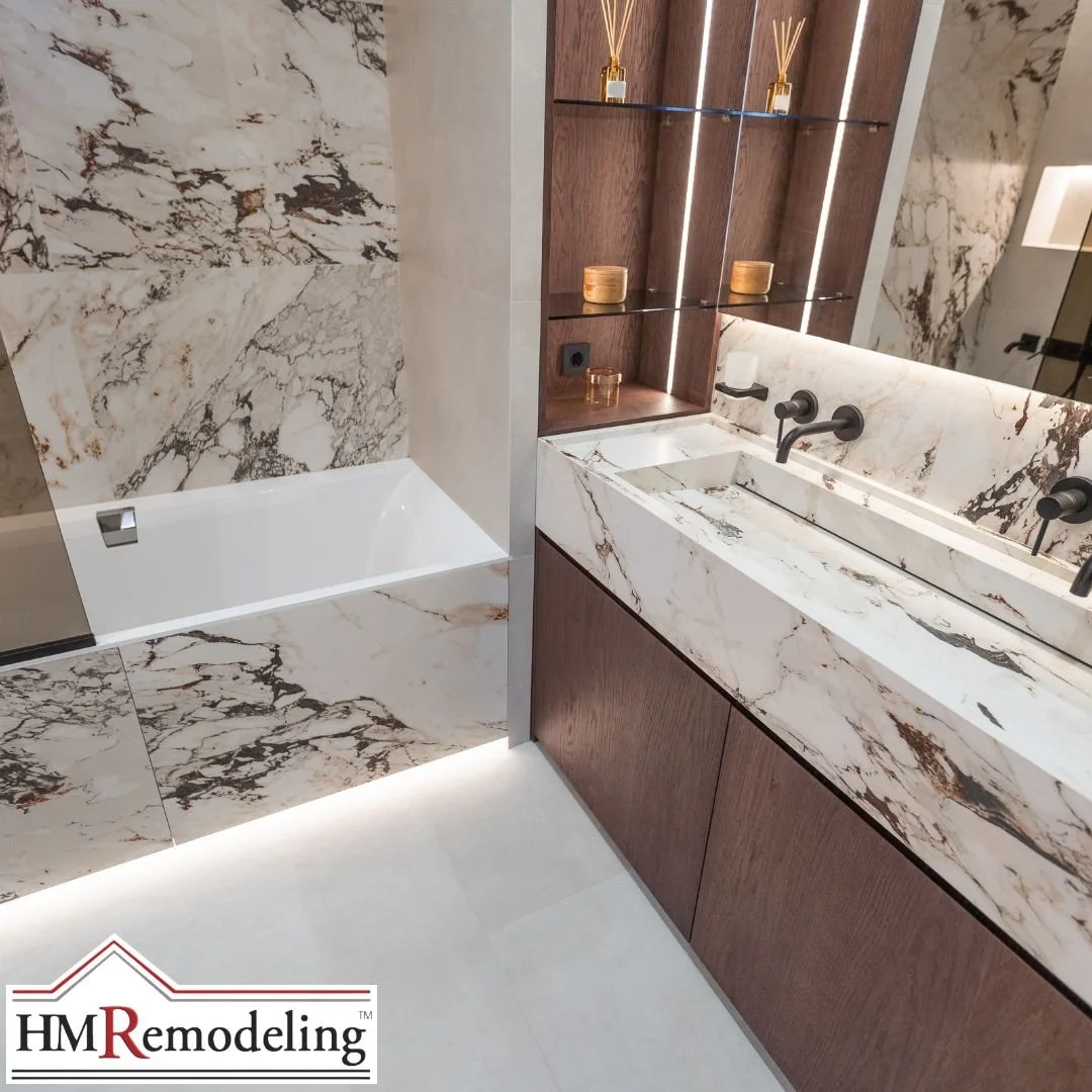 Marble stone vanity with integrated trough sink, matte black wall-mount faucets, LED backlit shelving, and soaking tub in a South Bend, Indiana bathroom remodel
