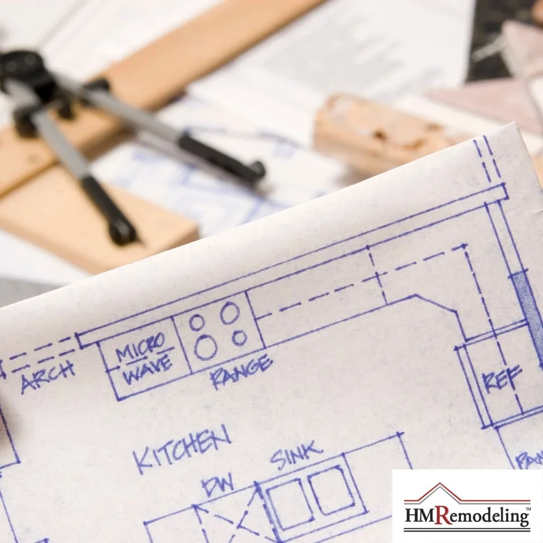 Kitchen remodel floor plan blueprint showing layout with microwave, range, sink, and dishwasher placement, with wood samples and clamps in background, by HM Remodeling in South Bend, Indiana