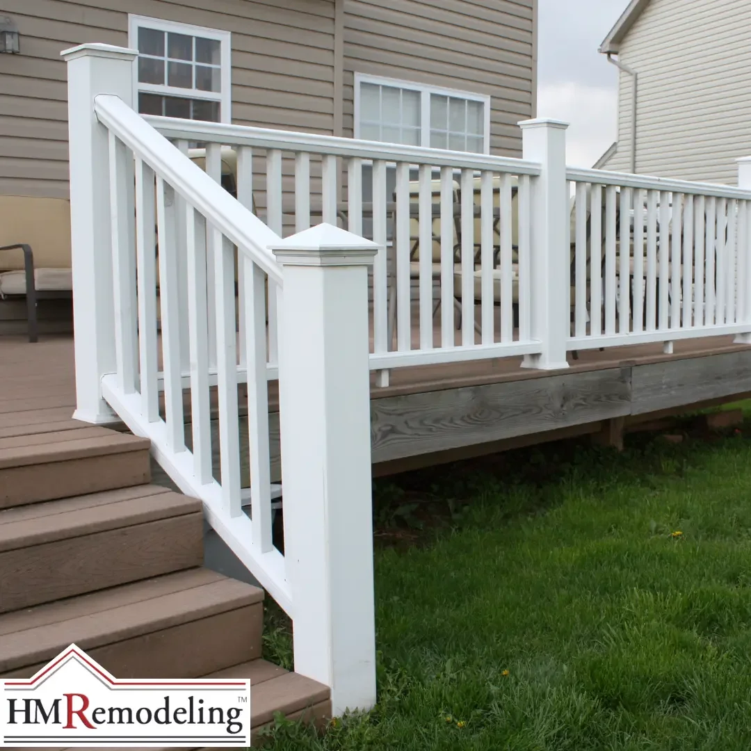 A white vinyl deck railing with balusters and a matching stair rail beside composite steps and green lawn at a South Bend, Indiana home.