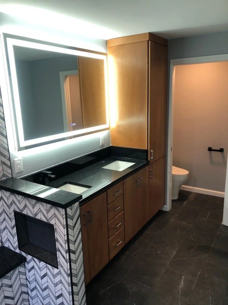 HM Remodeling bathroom renovation featuring LED backlit mirror and warm wood vanity in South Bend Indiana