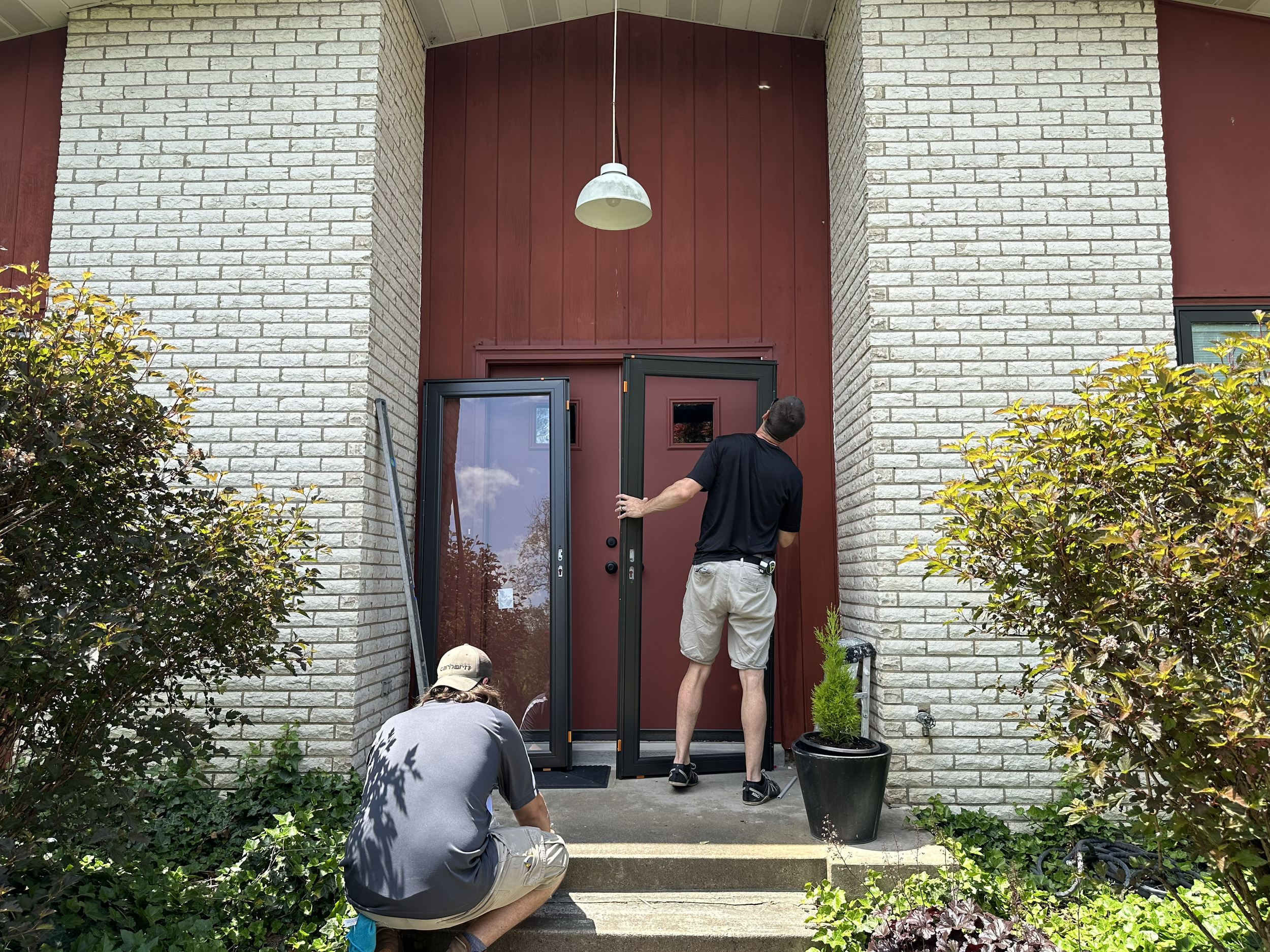 HM Remodeling crew installing commercial entry doors on a brick building in South Bend Indiana during a commercial renovation project