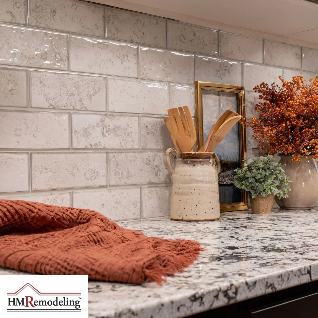 Kitchen backsplash and countertop installation featuring textured cream subway tile and granite countertop with gray veining by HM Remodeling in South Bend, Indiana