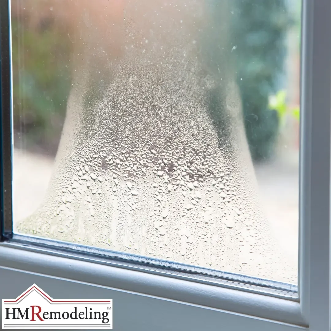 A close-up of heavy condensation and moisture beading on a window pane within a light-colored frame in a Michiana area home.