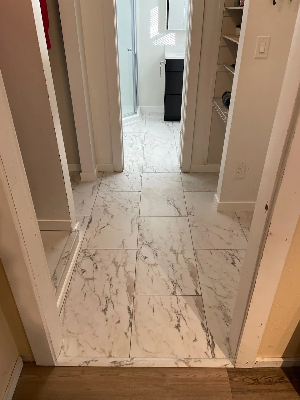 HM Remodeling hallway renovation featuring marble-look tile flooring and built-in closet in South Bend Indiana