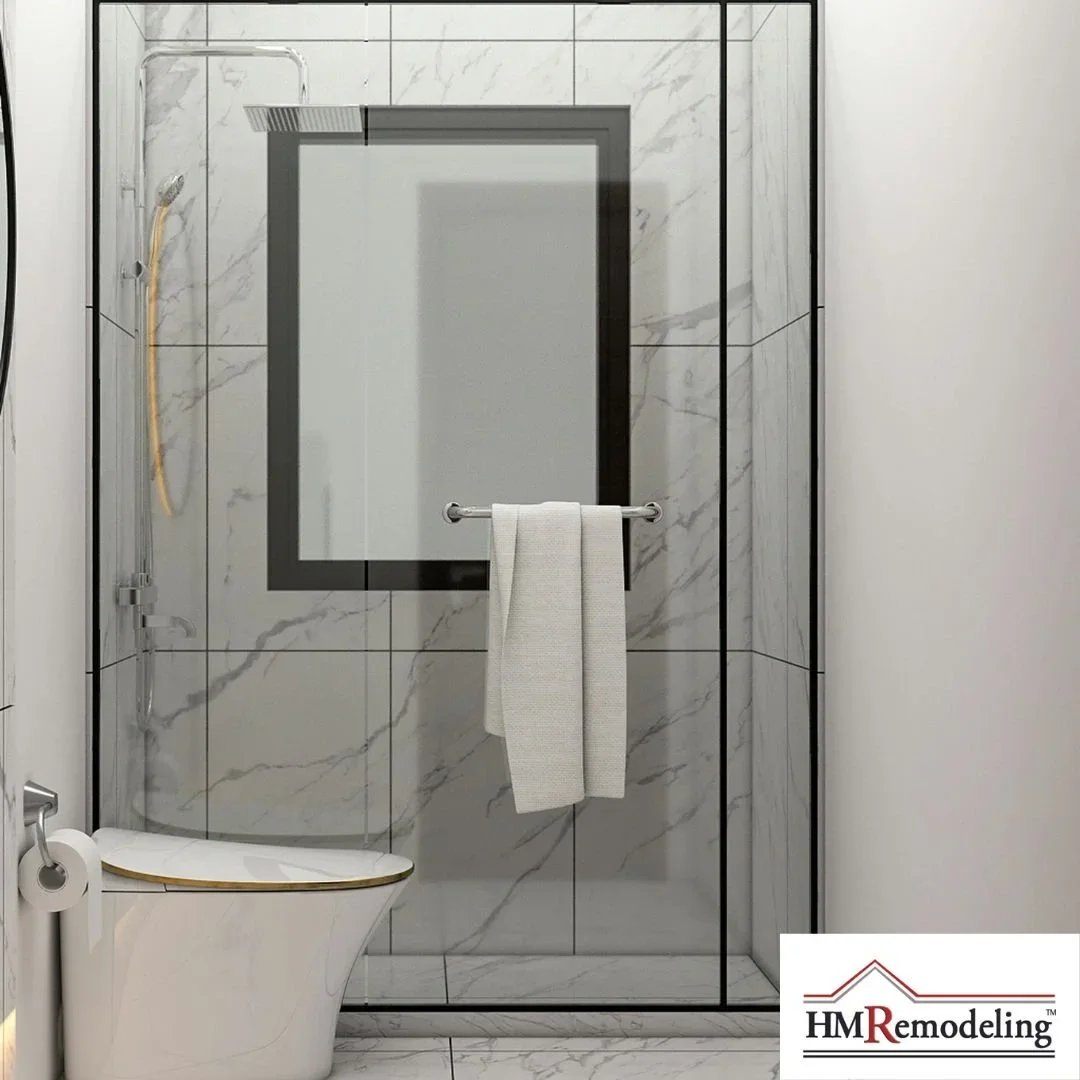 Small bathroom remodel with marble tile shower enclosure, black-framed glass door, rainfall showerhead, and modern toilet by HM Remodeling in South Bend, Indiana