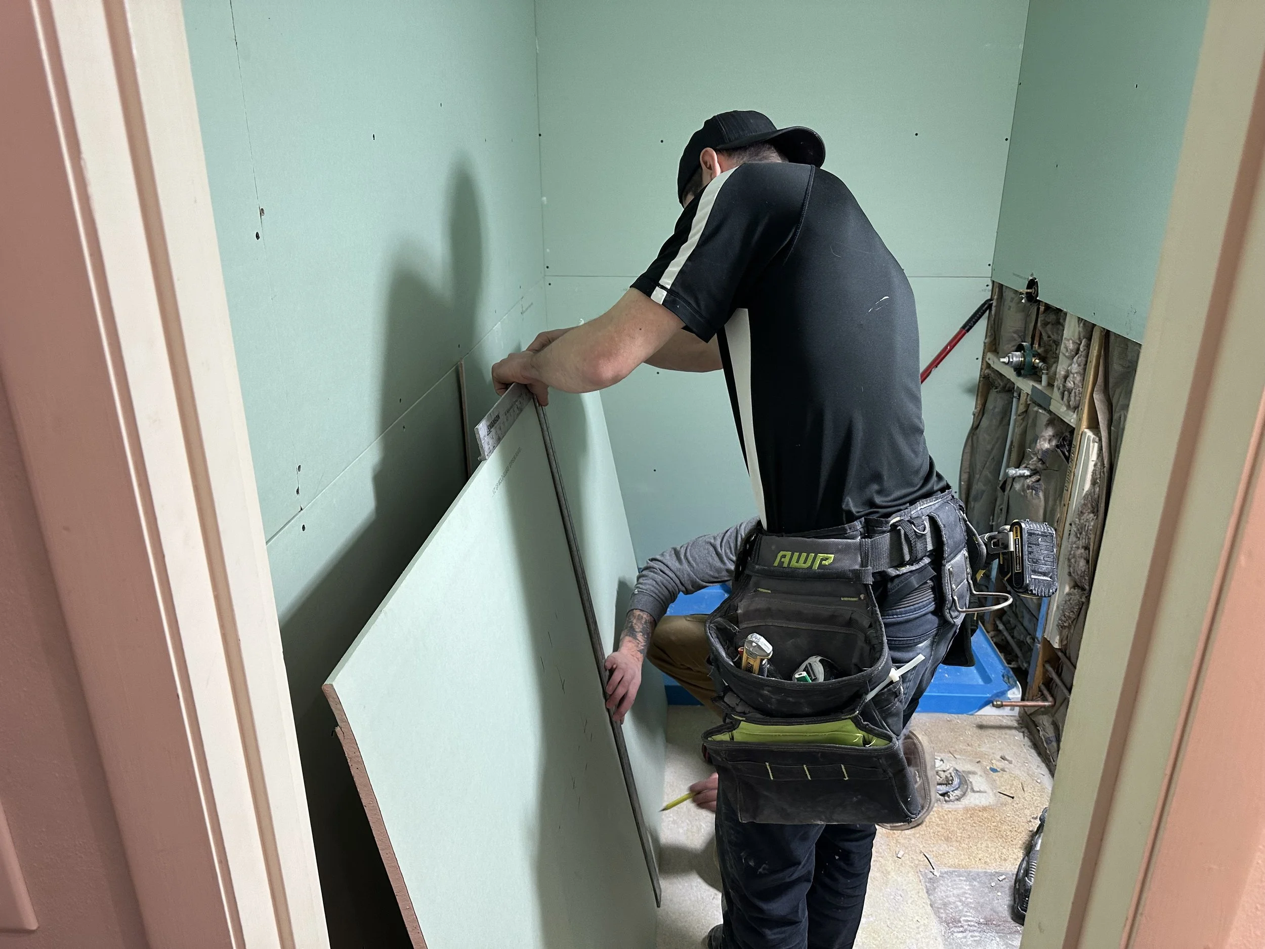 Two HM Remodeling crew members drilling during a home renovation project in South Bend Indiana