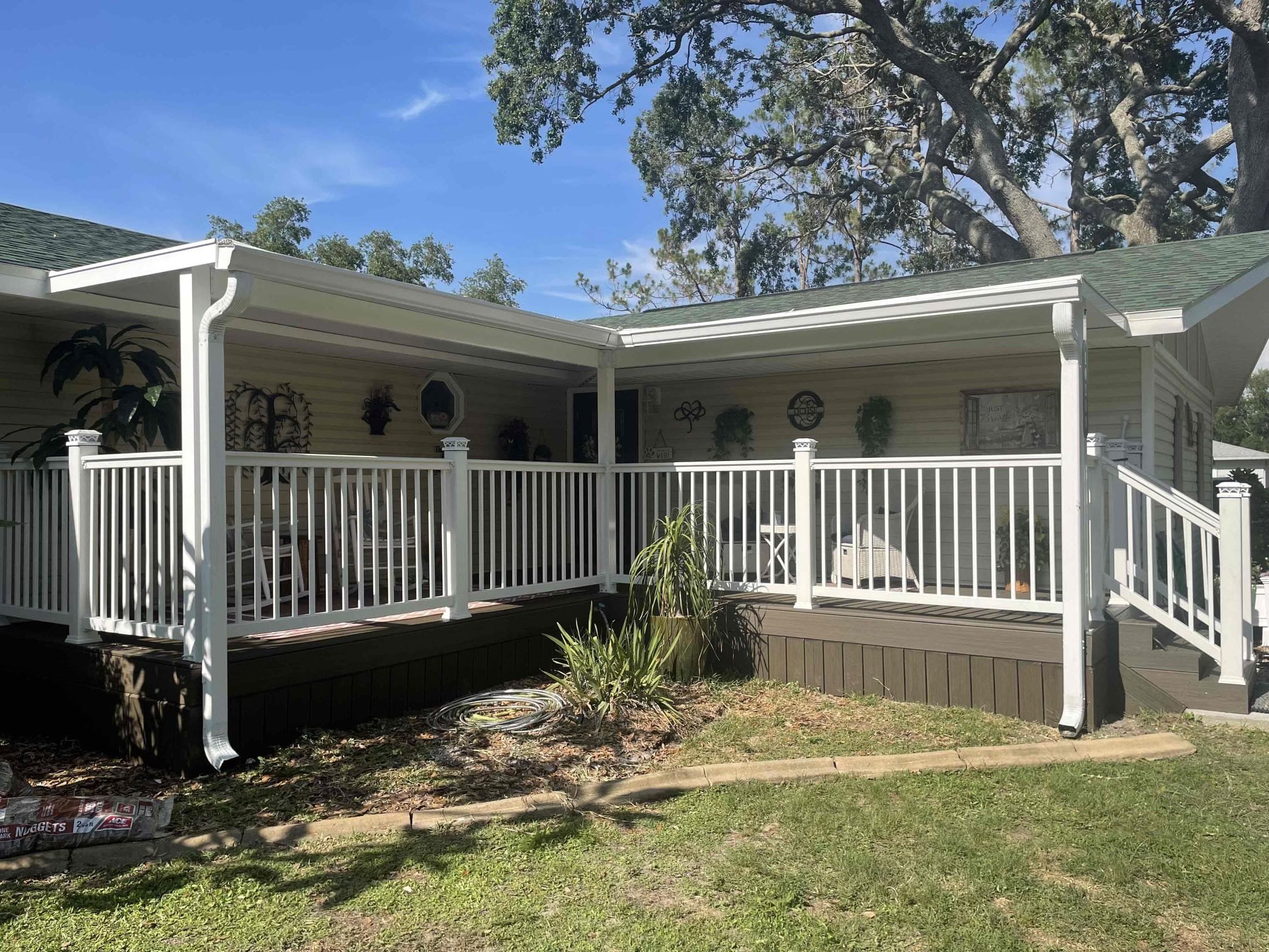 Custom covered porch addition built by HM Remodeling in South Bend Indiana featuring white vinyl railings, composite decking, and attached roof structure