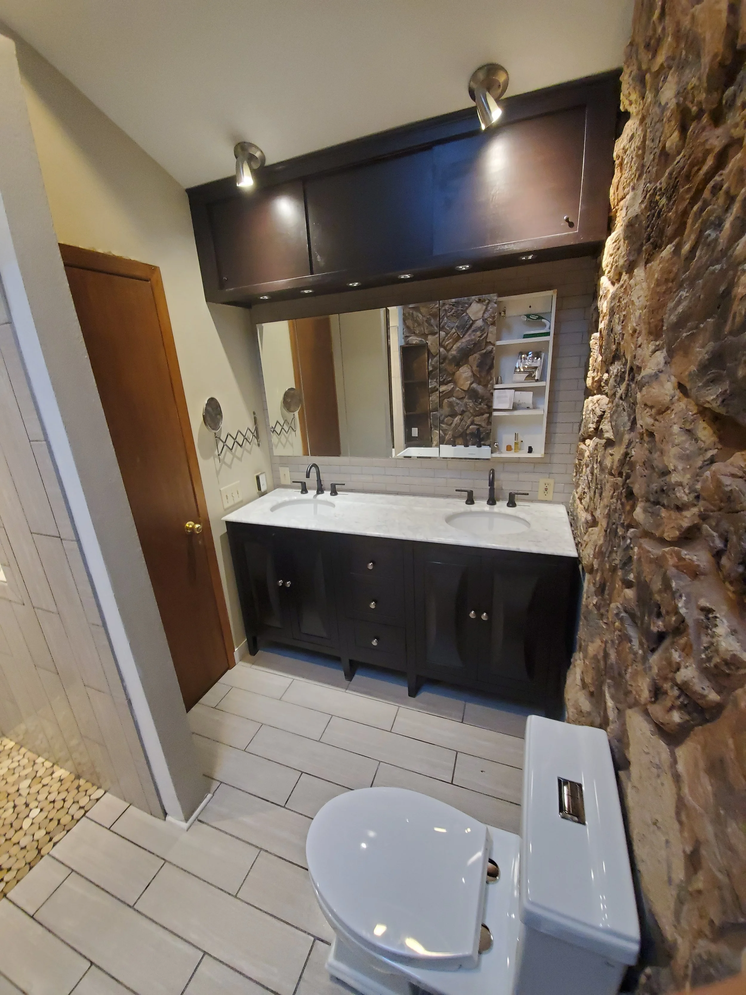 HM Remodeling bathroom with dark vanity and stone accent wall in South Bend Indiana
