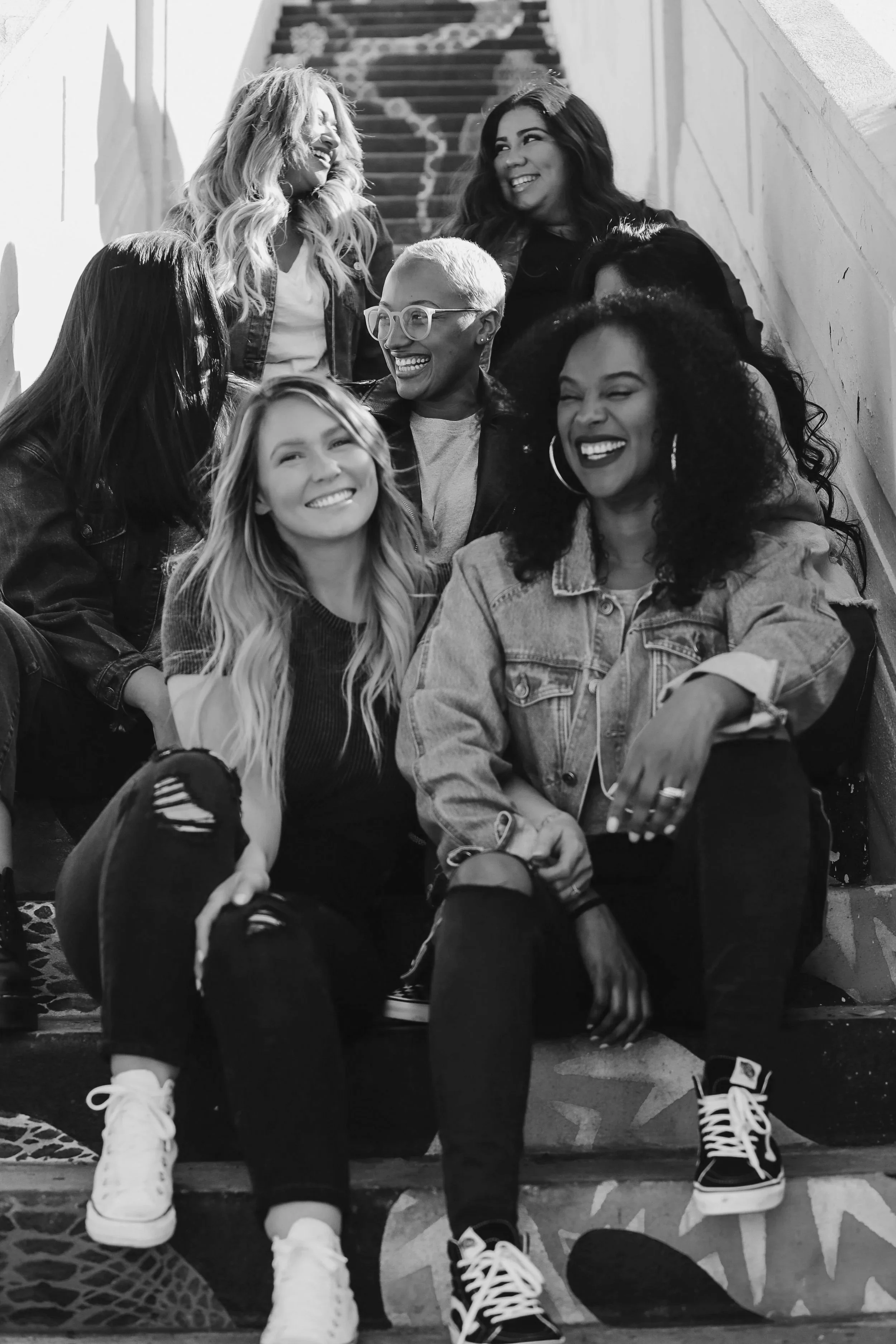 Group of women sitting on the stairs, laughing.