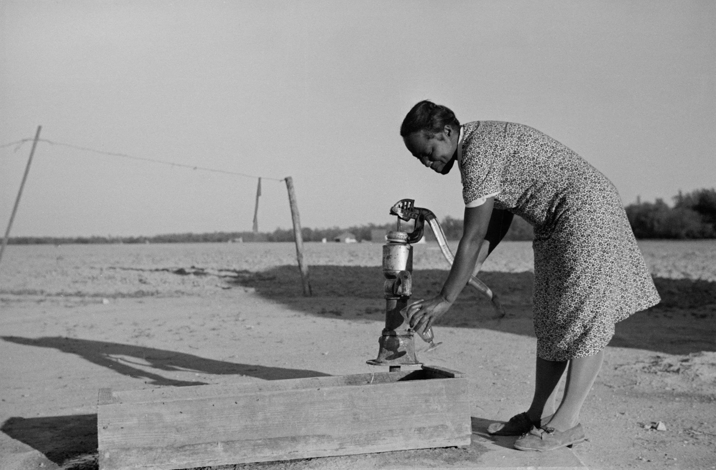 Rural woman pumping water.