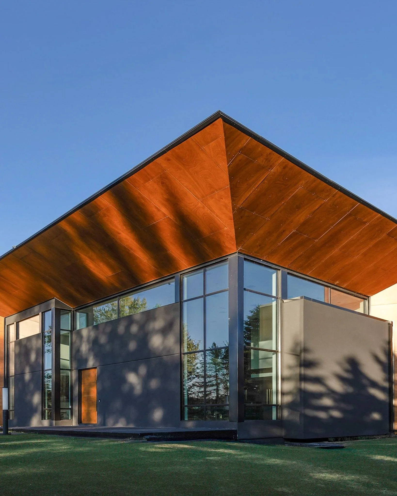 This custom home was designed with bold proportions, clean lines and carefully balanced materials to create a striking yet welcoming presence. From the dramatic roof overhangs to the expansive glazing and warm wood detailing, every exterior element w