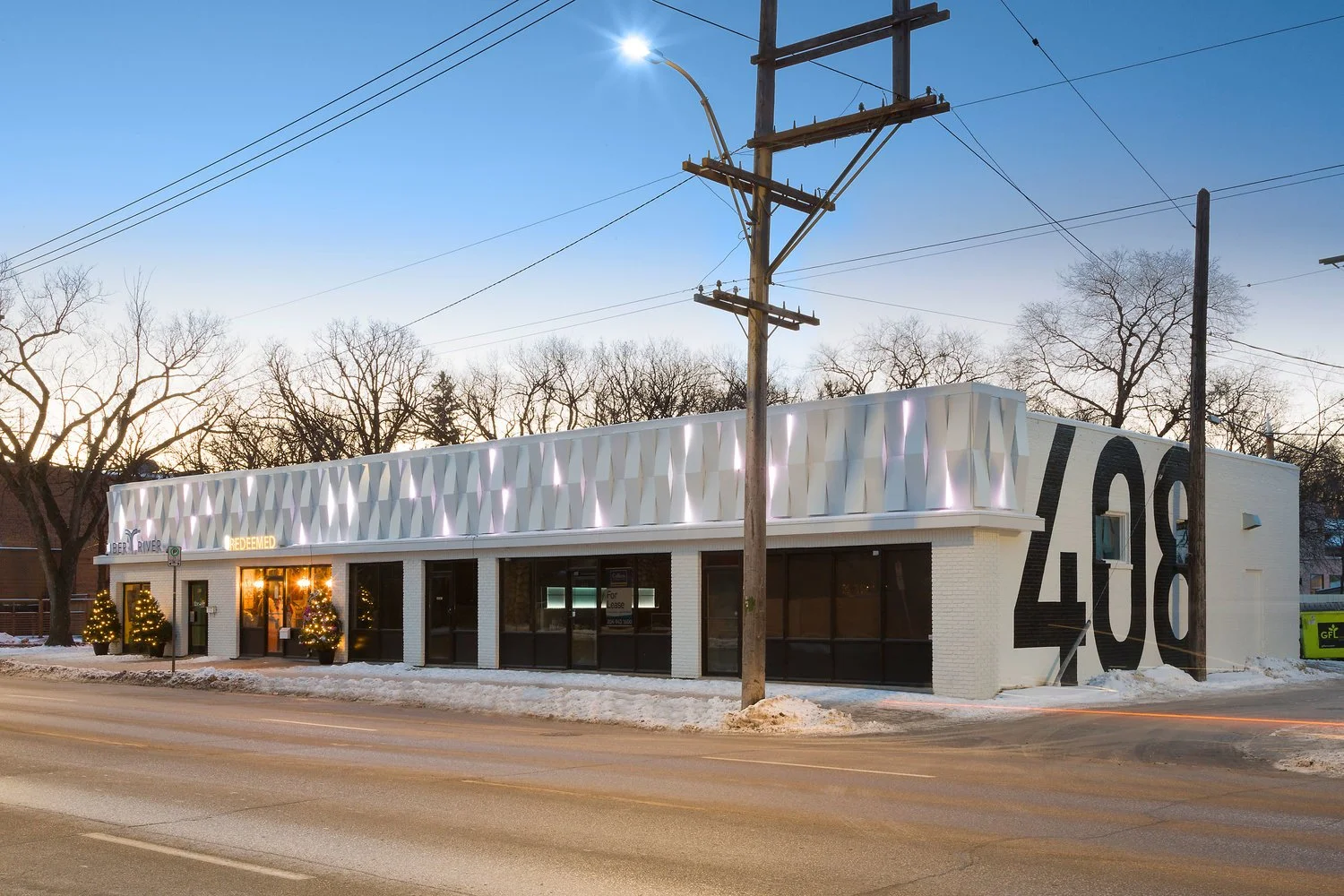 Modern commercial restaurant building with geometric white façade and large storefront windows.