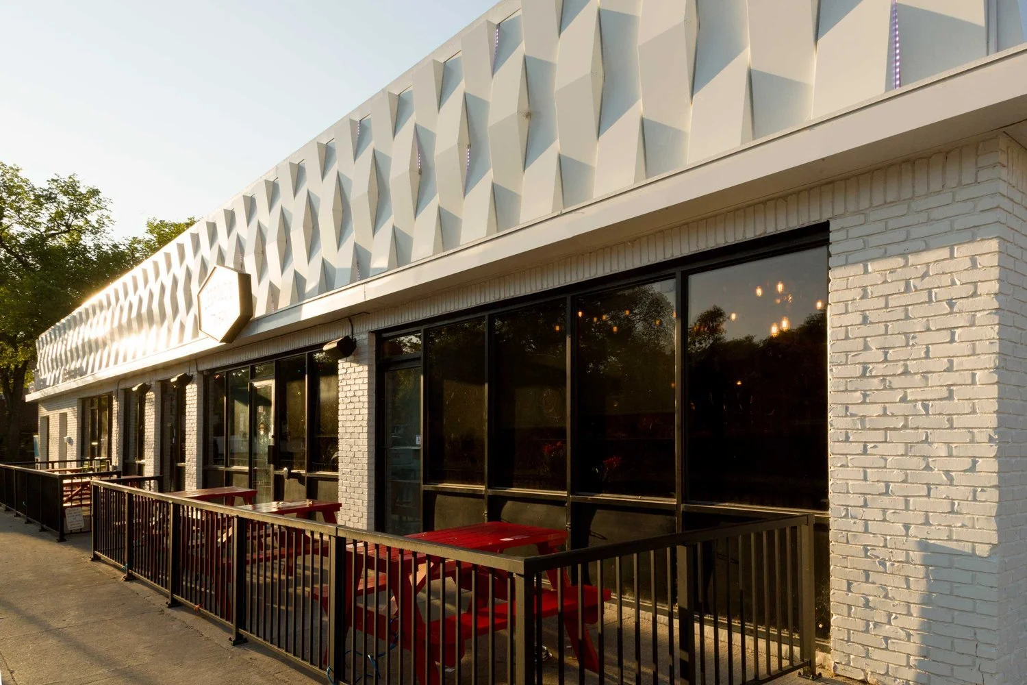 Modern commercial restaurant building with geometric white façade and patio