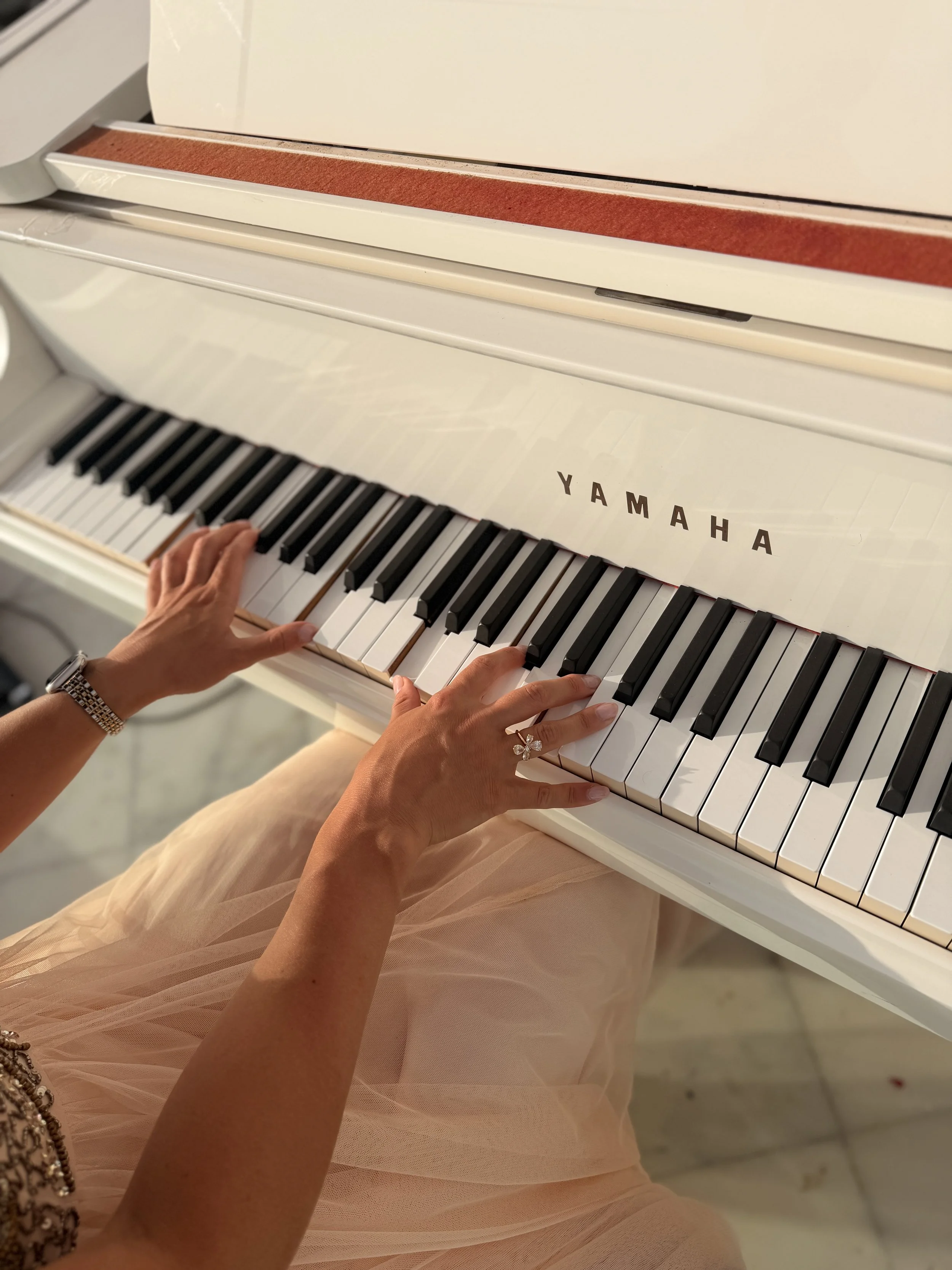 Kim Brooklyn speelt op een witte Yamaha-piano tijdens een liveoptreden
