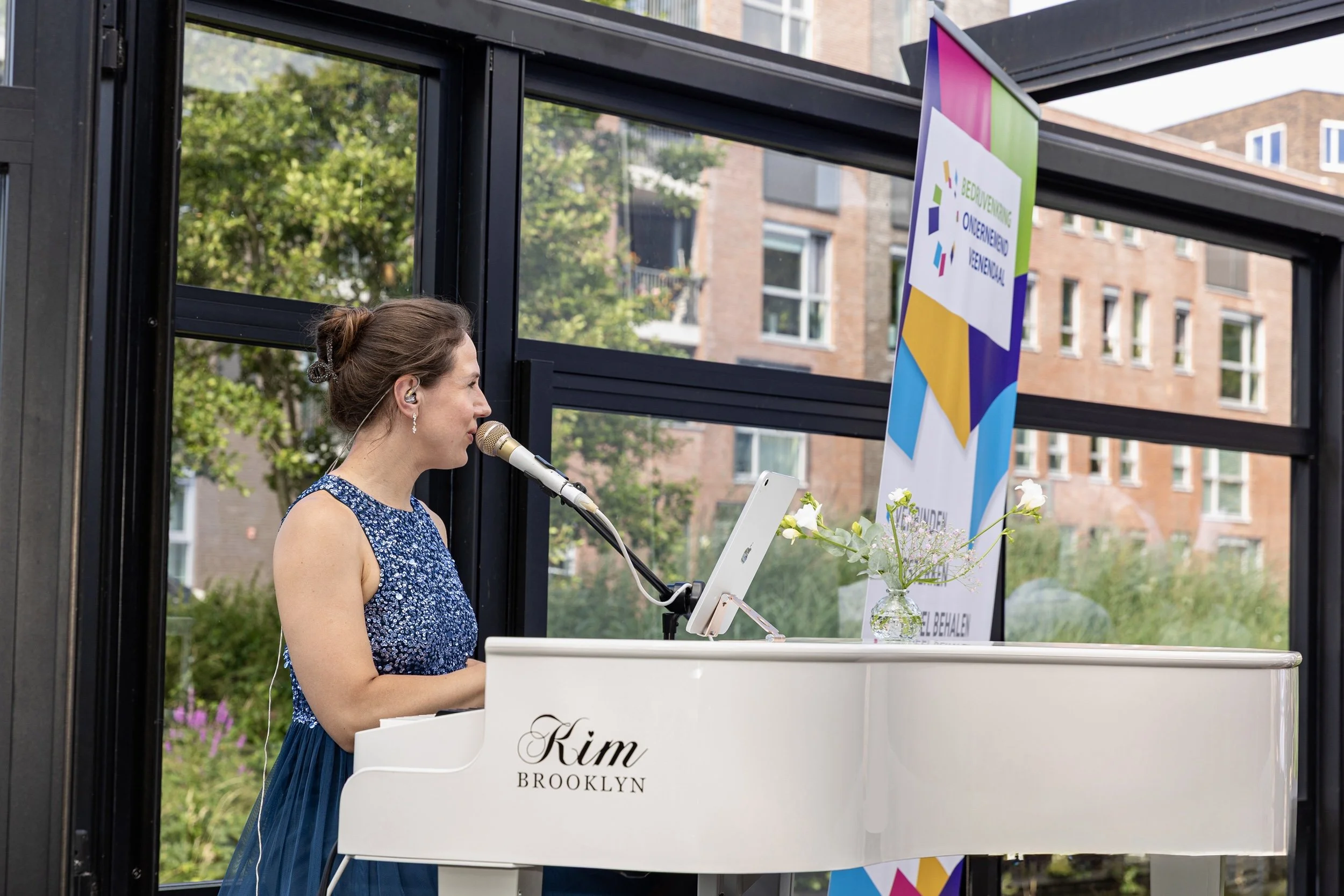 Kim Brooklyn treedt op met piano en zang tijdens een bedrijfsevenement