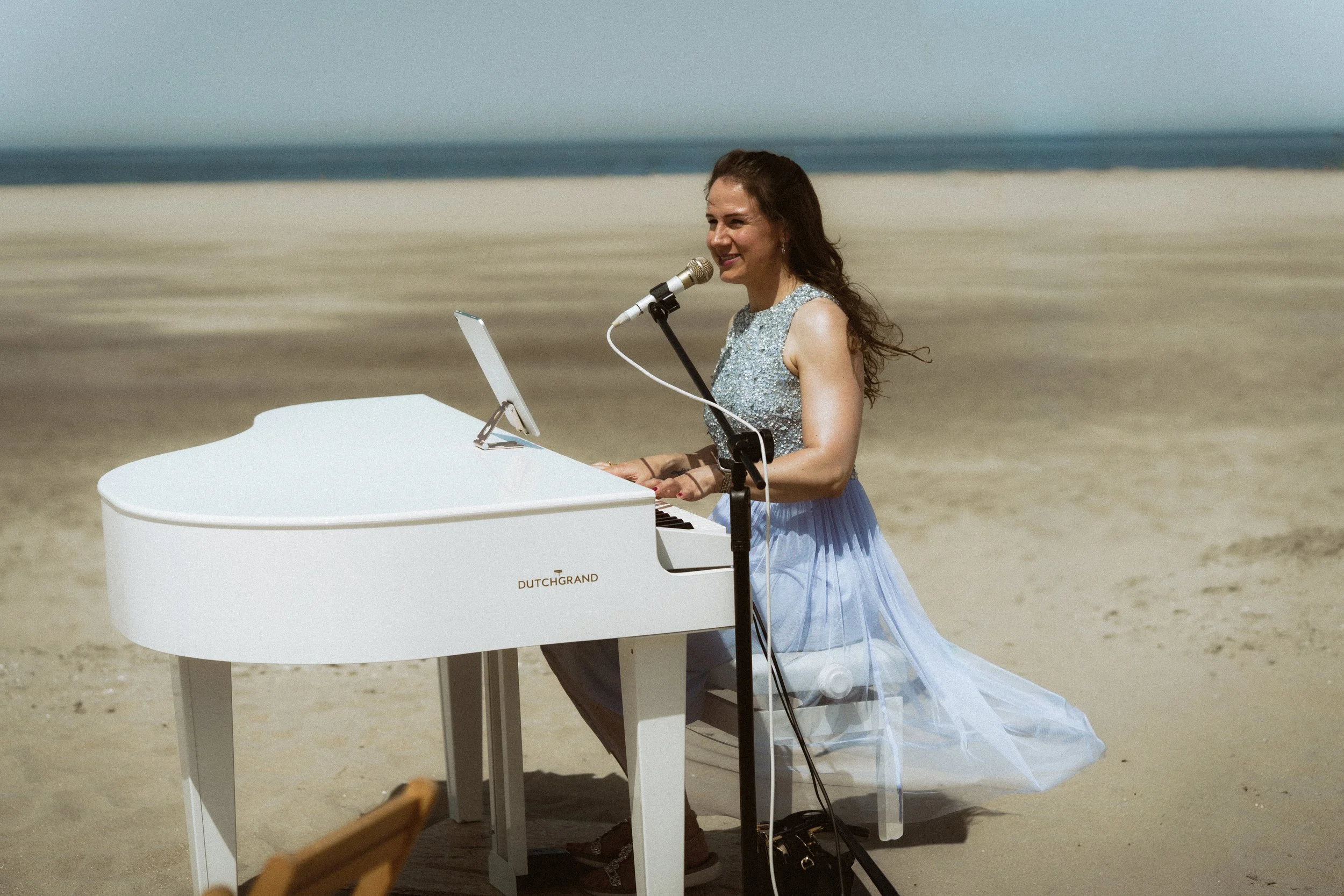 Kim Brooklyn zingt en speelt piano tijdens een strandbruiloft in Nederland