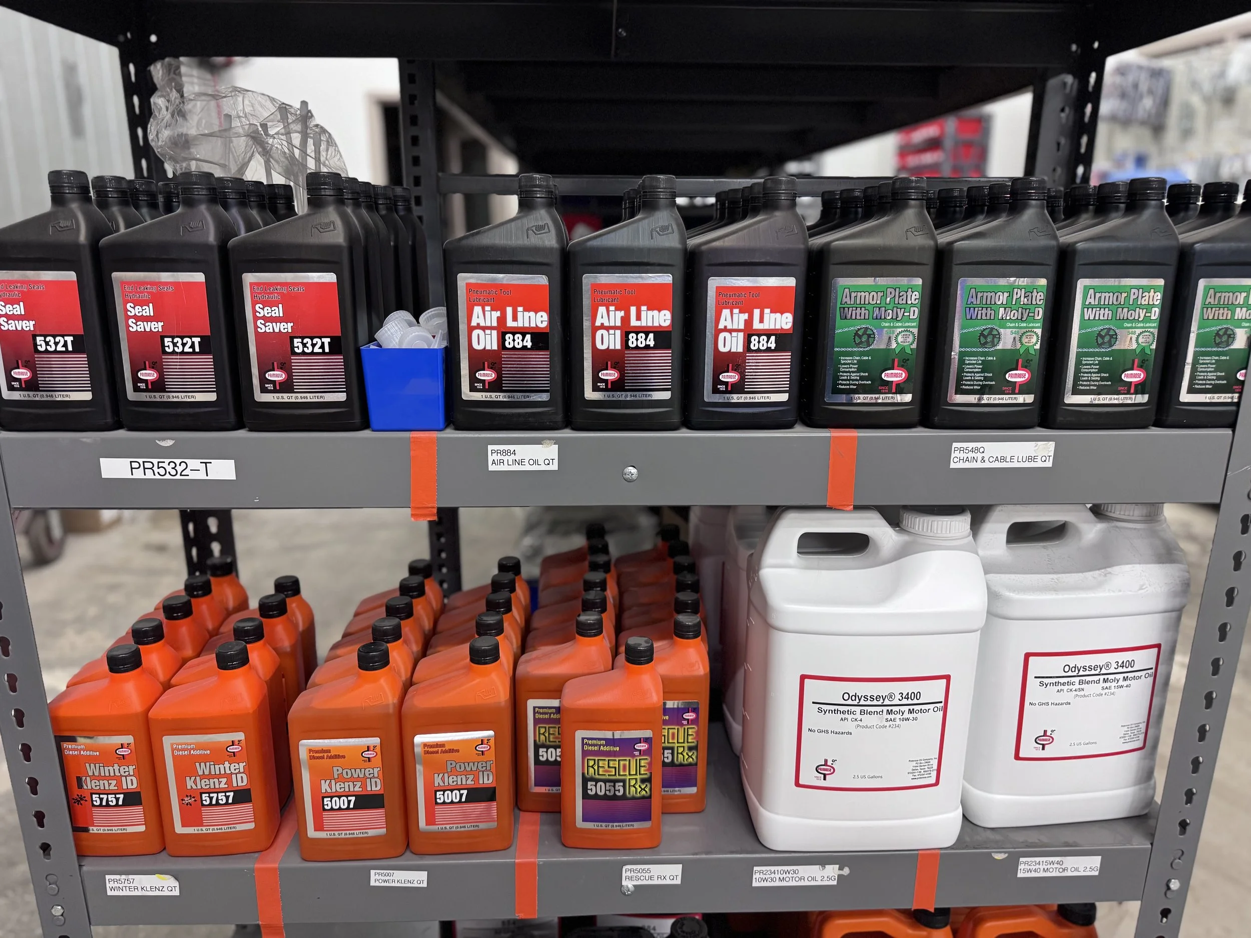 Shelf with automotive fluids including air line oil, seal savers, armor plates, engine oils, and additives.