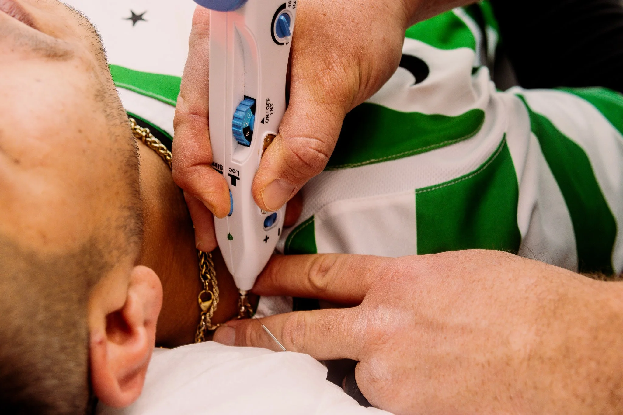 Person receiving an emergency medical test on their neck, with a health professional using a specialized medical device to examine or treat.