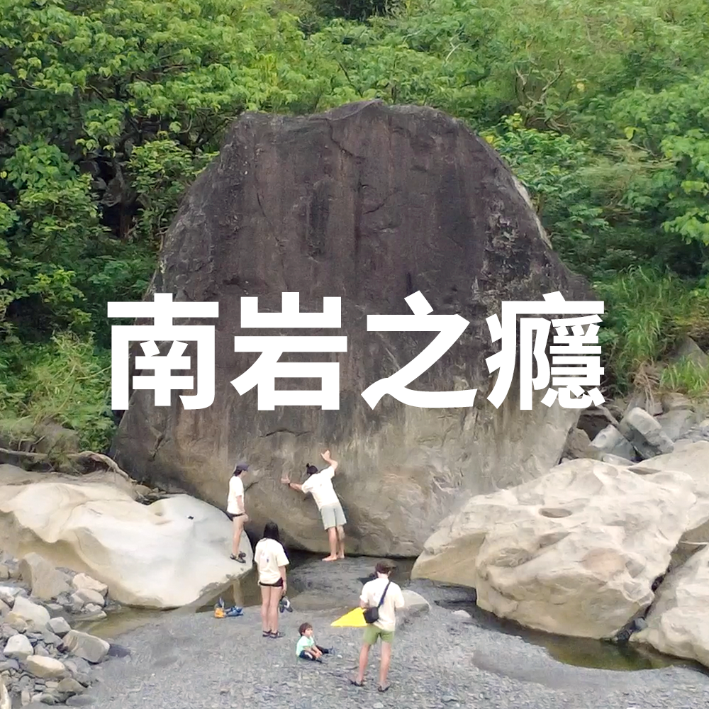 People standing and purveying a large boulder in a riverbed with trees in the background. White Mandarin text overlaid on the image exclaims it as the logo for an outdoor bouldering area devlopment project in Taiwan.