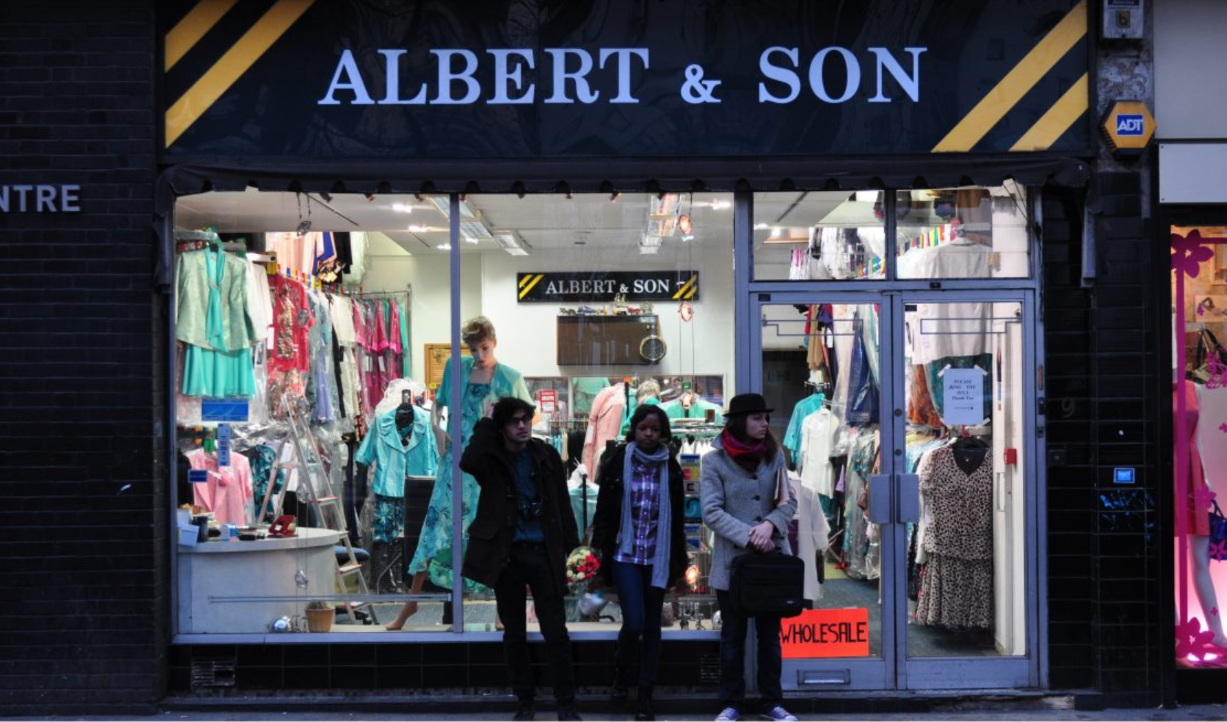 3 young people standing in low evening light in front of a clothing shop called Albert and Sons