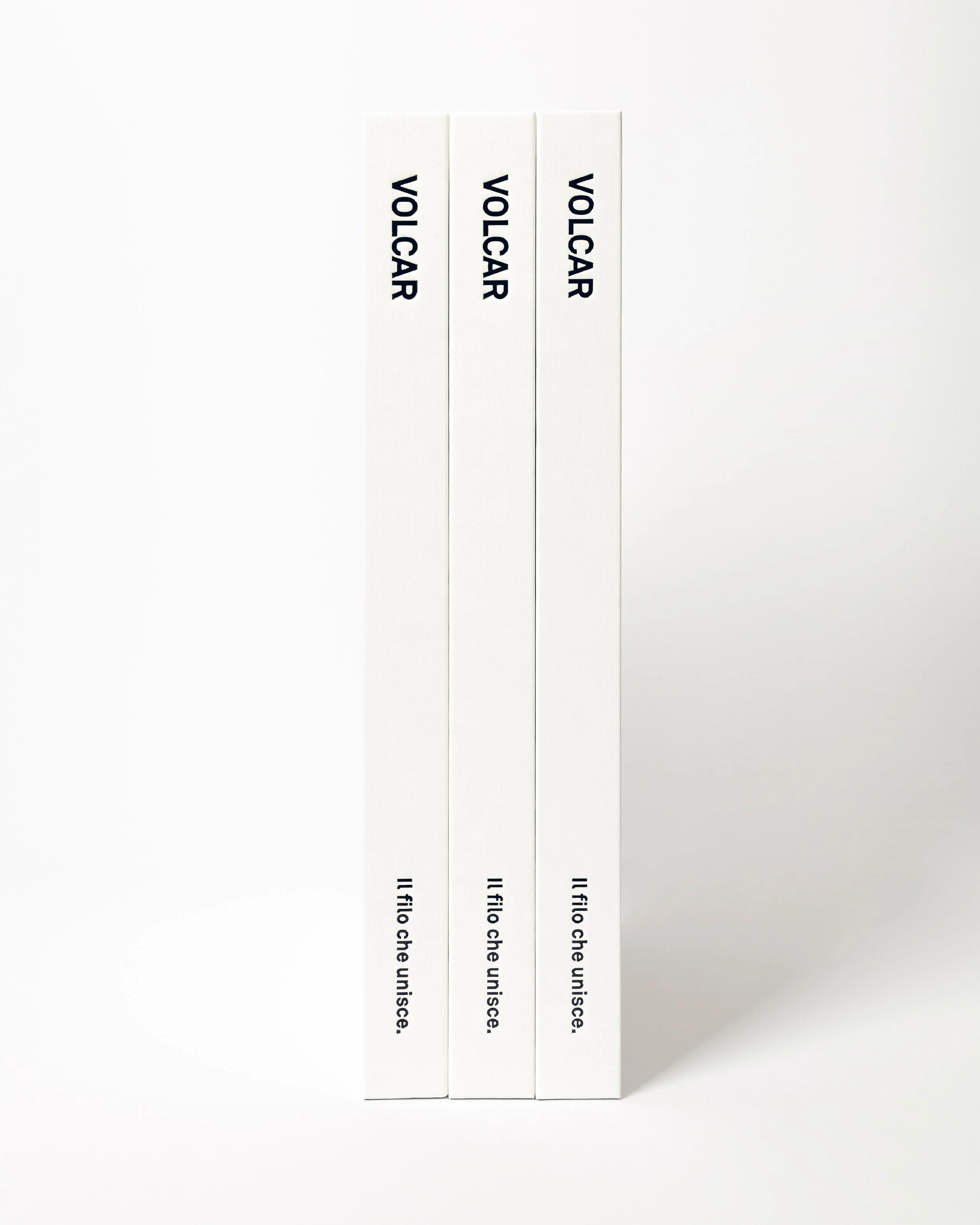 Tre libri con copertina bianca, disposti verticalmente, con la scritta 'VOLCAR' e 'Il filo che unisce'.