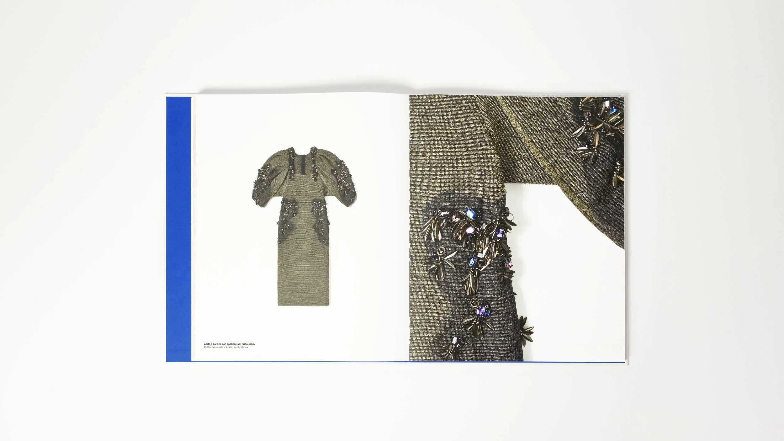 Libro aperto che mostra un vestito da sera con applicazioni metalliche e dettaglio dello stesso vestito.