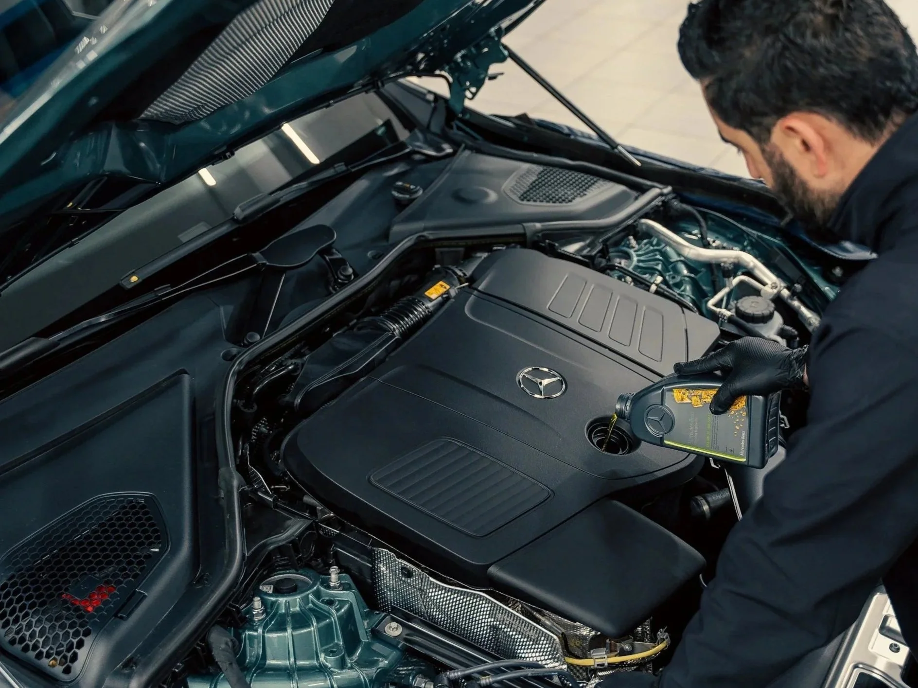 Technician performing scheduled maintenance on a Mercedes-Benz engine.
