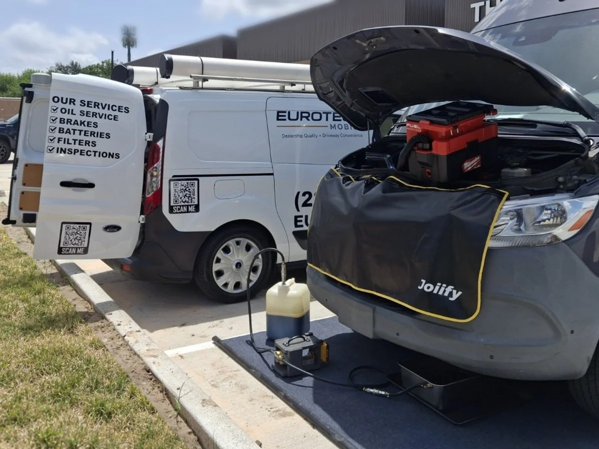 Mercedes-Benz Sprinter with its hood open beside the EuroTech Mobile service van, with a protective cover and ground mat.