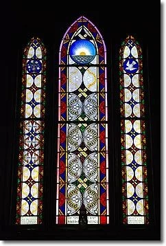 Colorful stained glass window with religious imagery and geometric patterns.