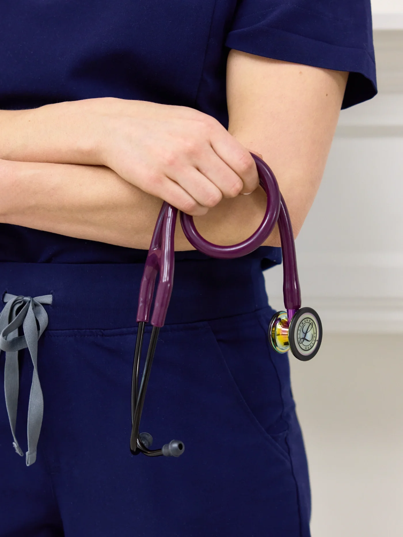 Dr. Ashley Taylor, ND, RMT wearing navy scrubs holding a purple stethoscope with a gold accent in Guelph, Ontario