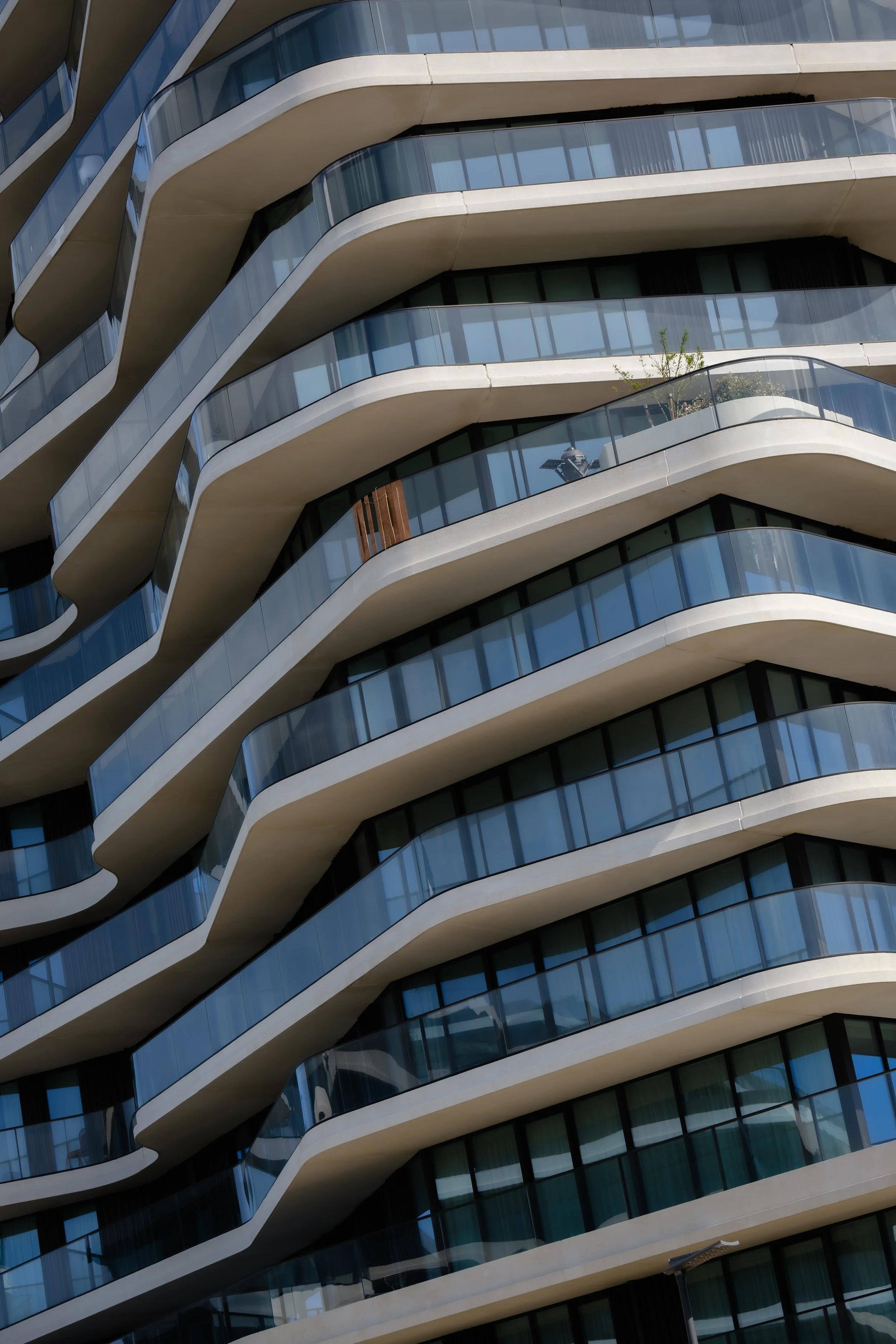 Moderne hoogbouw met golvende balkonranden en glazen balustrades.