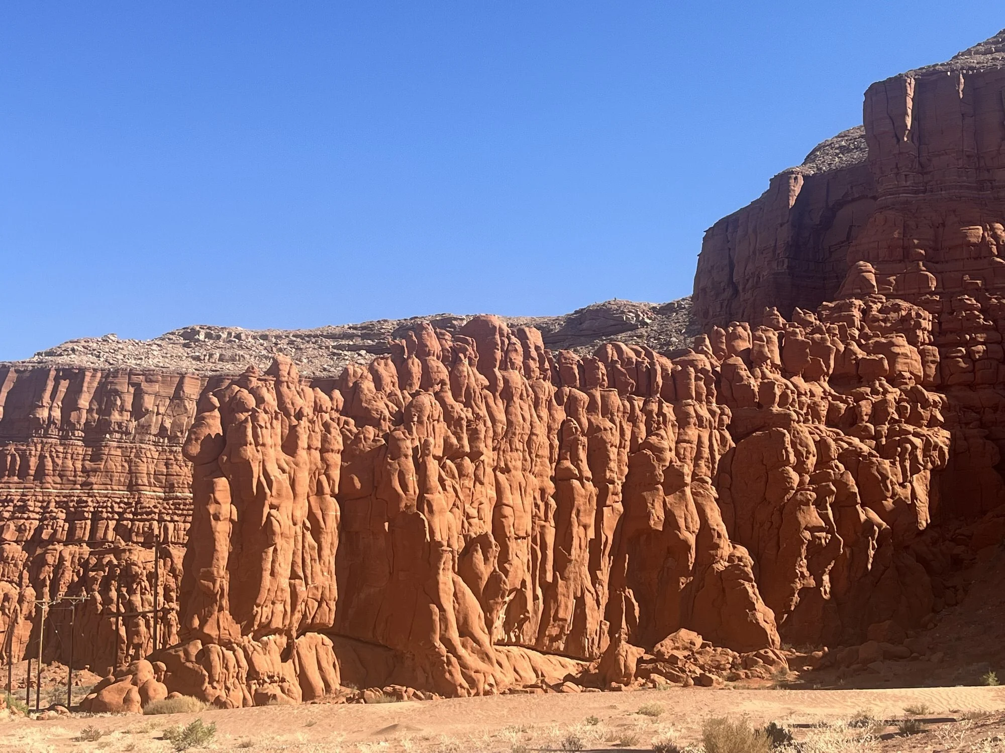 Red rock formations in a desert landscape with a clear blue sky.