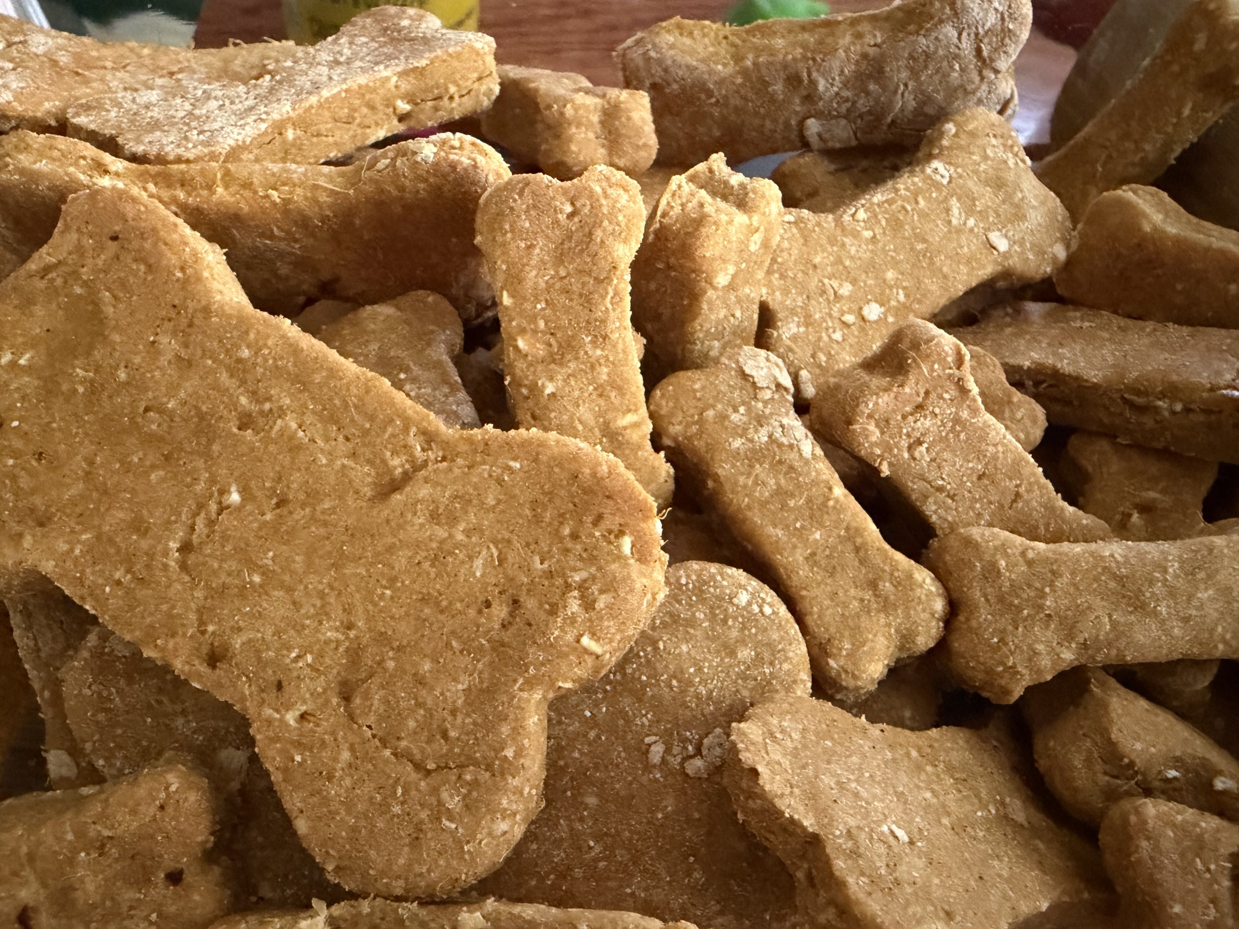 Close-up of brown, crispy, baked cookies or crackers stacked on top of each other on a wooden surface.