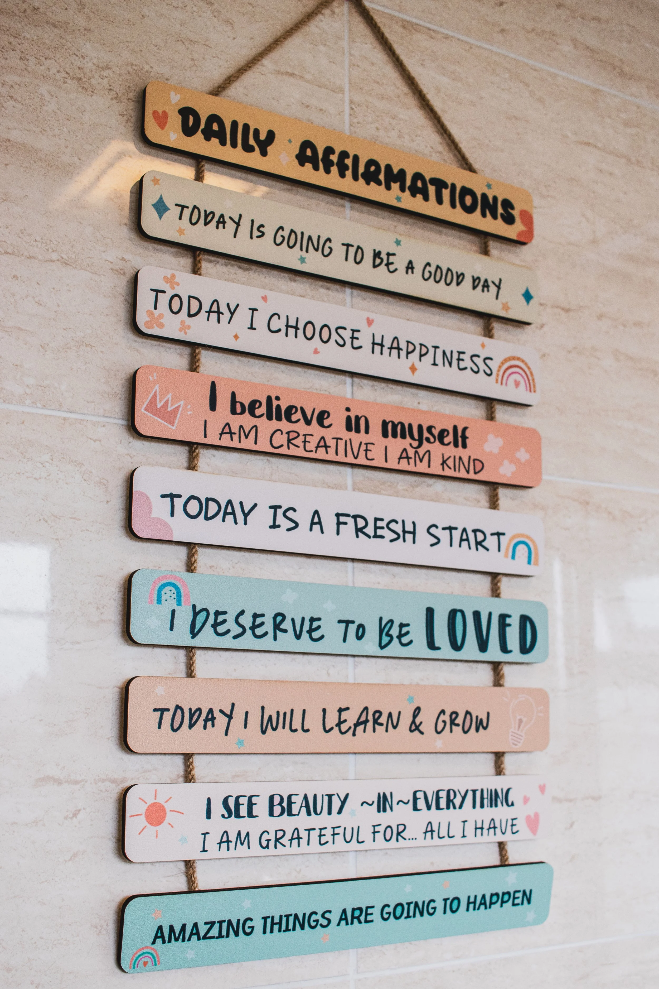 Colorful inspirational daily affirmation signs hanging on a wall with motivational messages.
