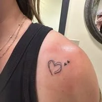 Tattoo on person's shoulder with a heart and the text 'B+' inside it.