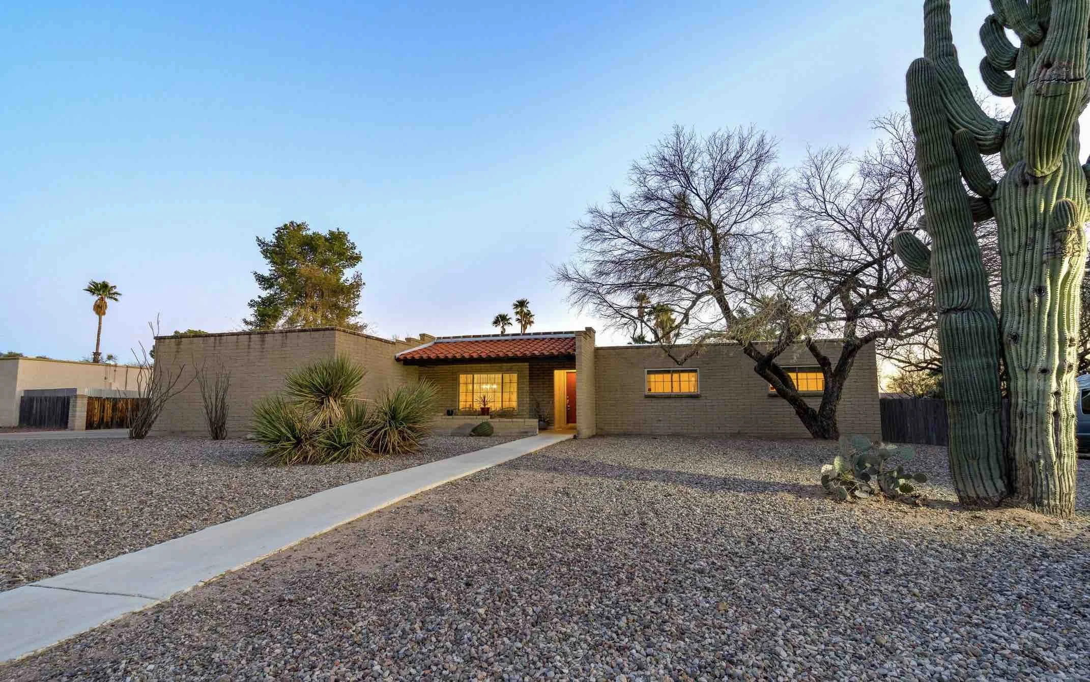 front-of-brick-adobe-house-with-saguaro-cactus