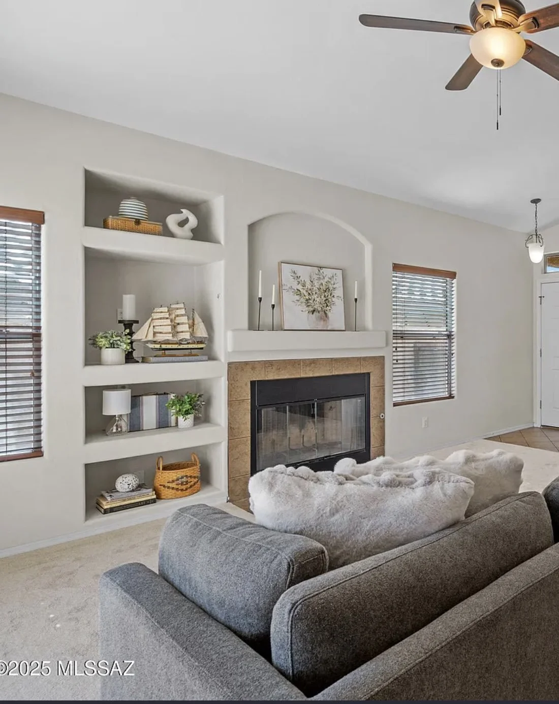 Living room with a grey sofa, decorative pillows, and desert fixtures representing Tucson, Arizona vibes.