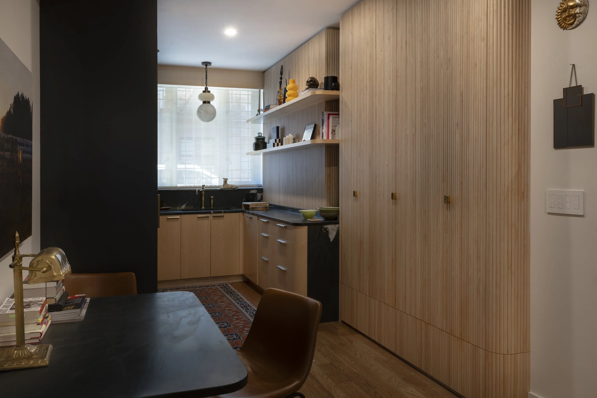 Millwork detail: Custom fluted wood kitchen cabinetry with sculptural detailing in a Brooklyn duplex.